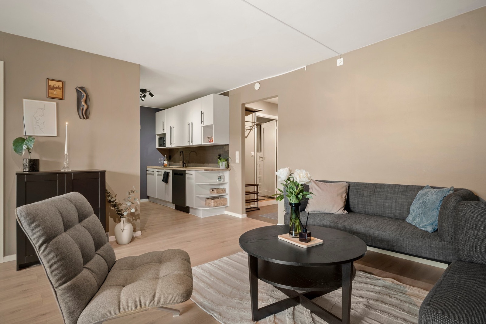 Stuen er enkel å møblere med sofagruppe, spiseplass, hyller, reoler og bilder. Galleribilde