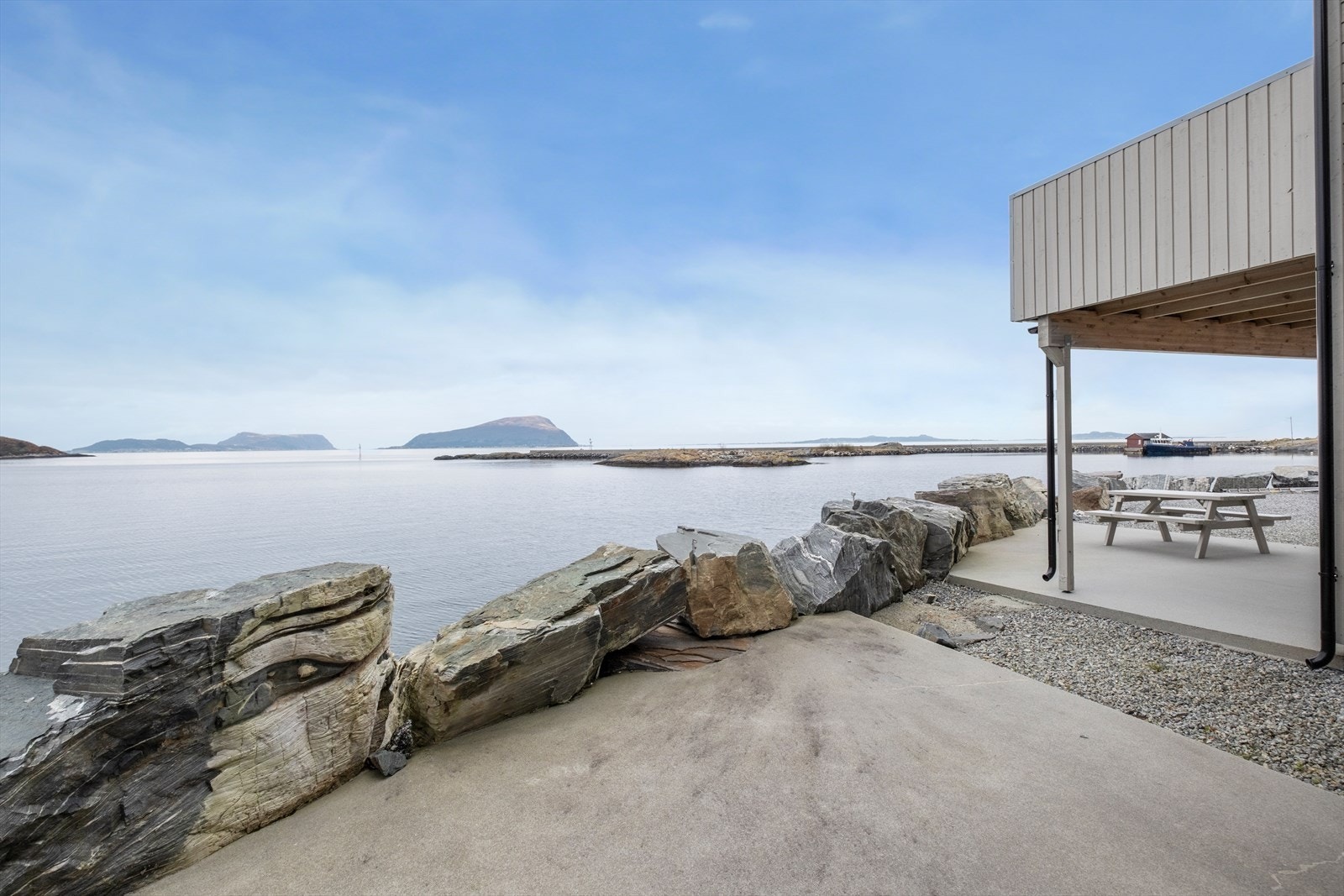 Uteområdet inkluderer en steinlagt plass med nærhet til sjøen, perfekt for rolig rekreasjon. Galleribilde