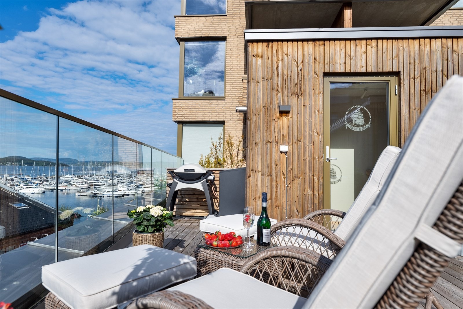 Glassrekkverk langs hele terrassen sikrer en uforstyrret utsikt over fjorden og båtlivet. Galleribilde