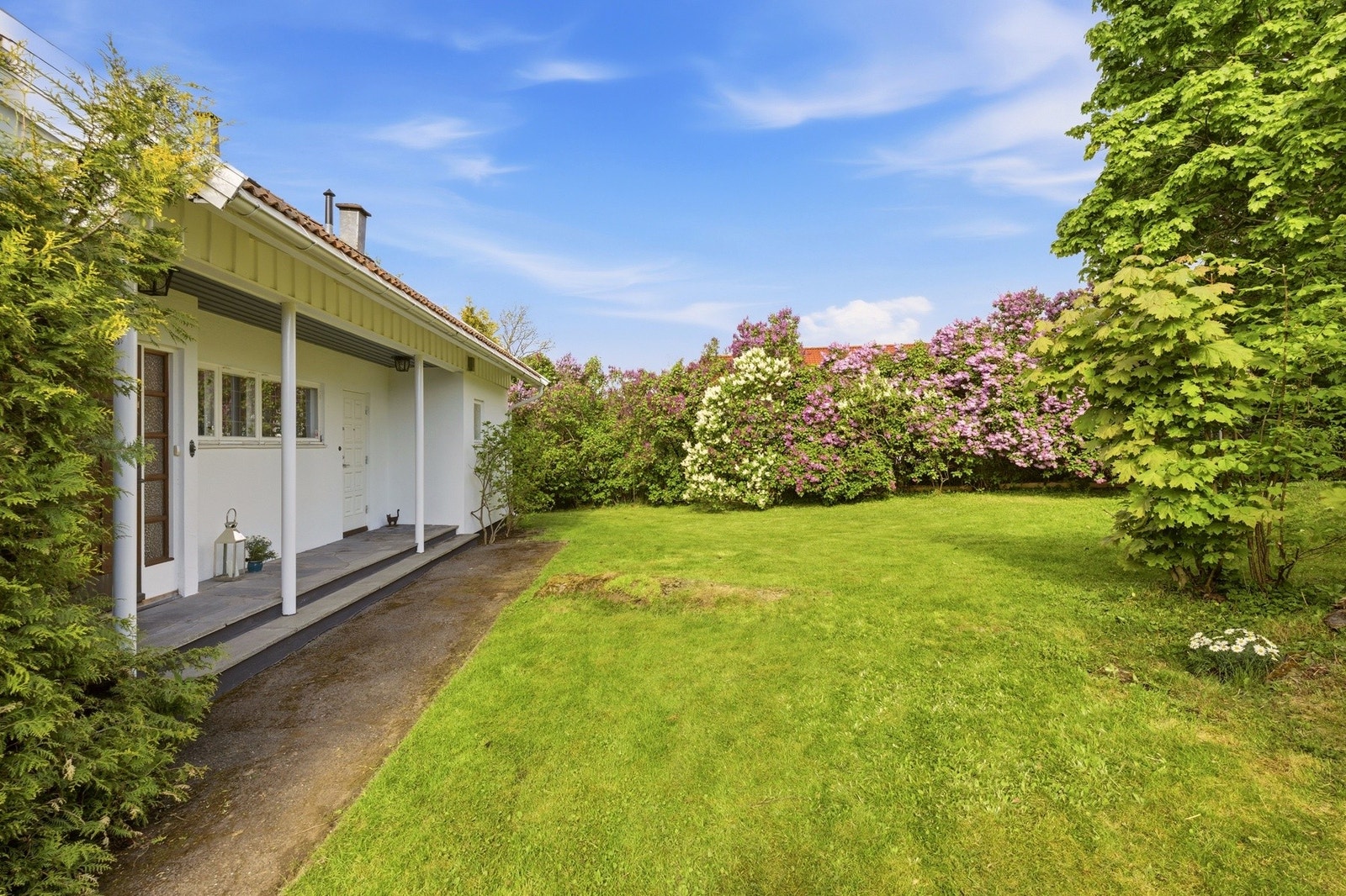 Eiendommen har gode solforhold, herunder kveldssol på gressplenen bak huset. Galleribilde