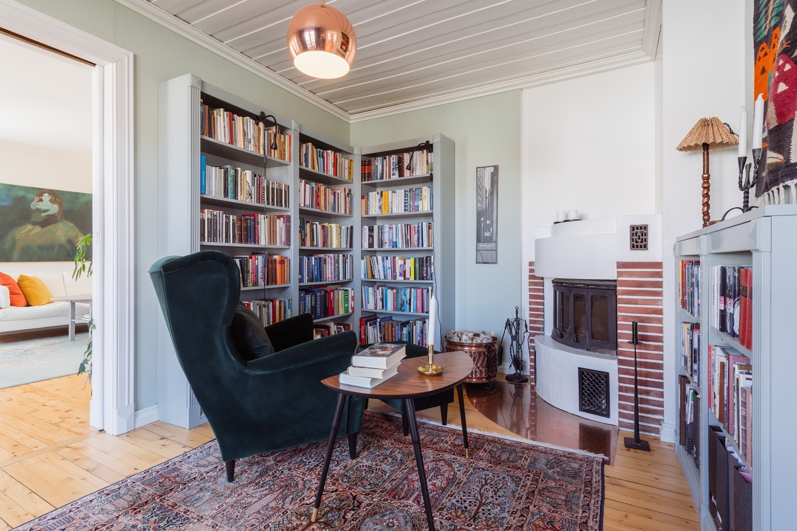 Koselig peisestue/bibliotek med peis og spesialbygget bokhylle. Galleribilde