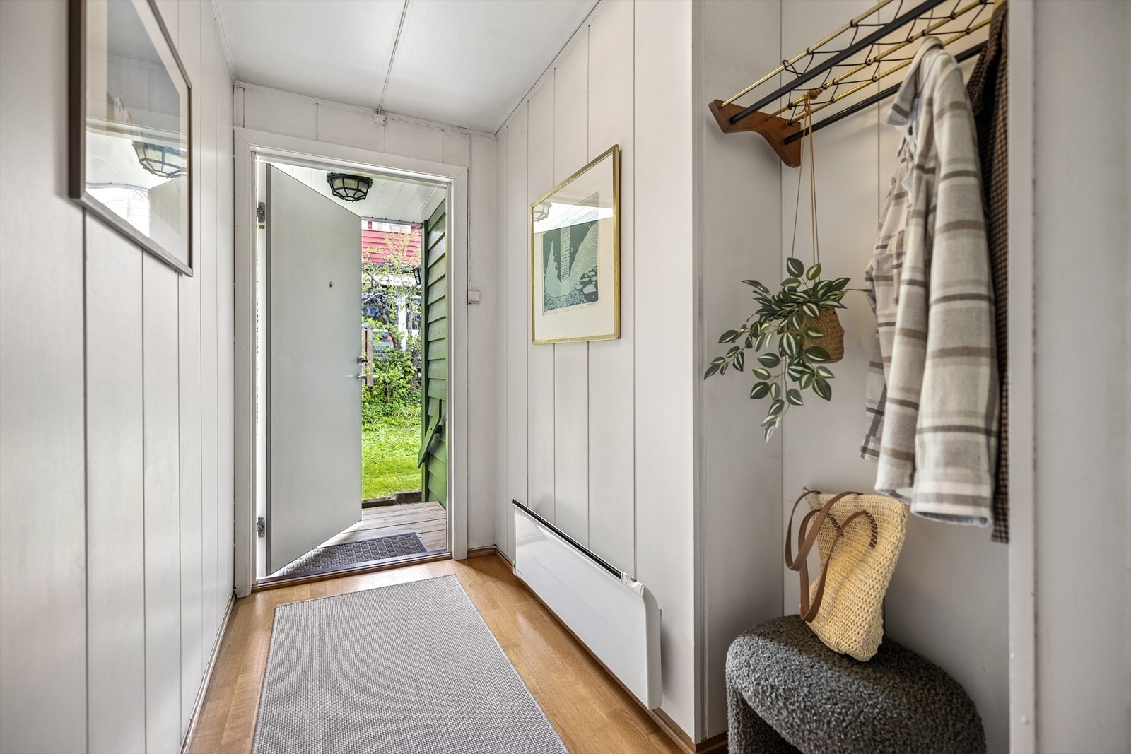 Lys entré med god plass til å henge fra seg yttertøy på knagger og sette fra seg sko. Galleribilde