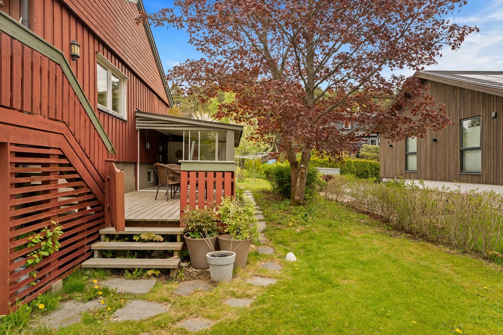 Tomten er lett kupert med gruset gårdsplass. Galleribilde