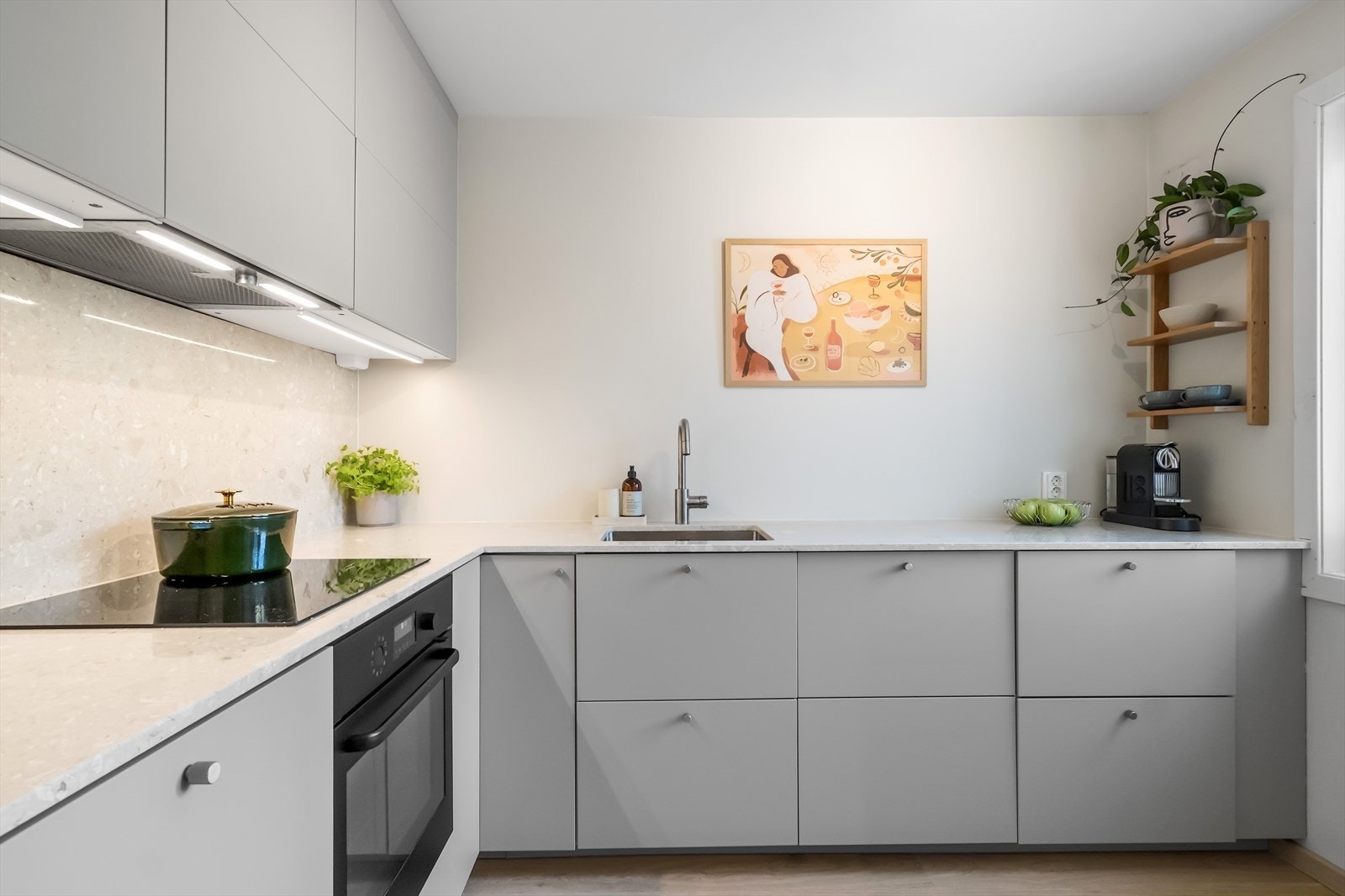 Stilrent, lukket kjøkken fra 2023 med glatte fronter og benkeplate i terrazzo-marmor, som gir et moderne og eksklusivt uttrykk Galleribilde