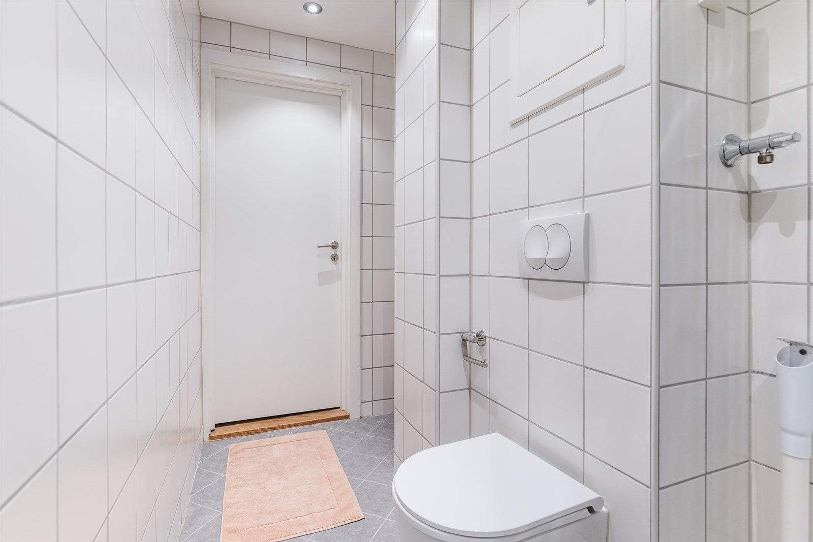 Innredning og garnityr på badet består av toalett, dusjhjørne med innfellbare glassdører og baderomsmøbel med servant og ettgrepsbatteri. Til høyre for toalettet er det en stor kran med et rør under (antatt opplegg for vaskemaskin, ikke undersøkt). Galleribilde