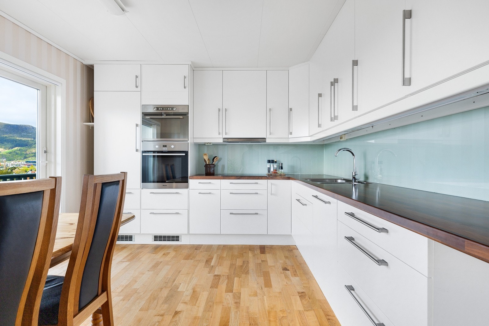 Man har god plass til spisebord på kjøkken også, samt direkte utgang til terrassen som gjør det enkelt å servere måltidet utendørs. Galleribilde