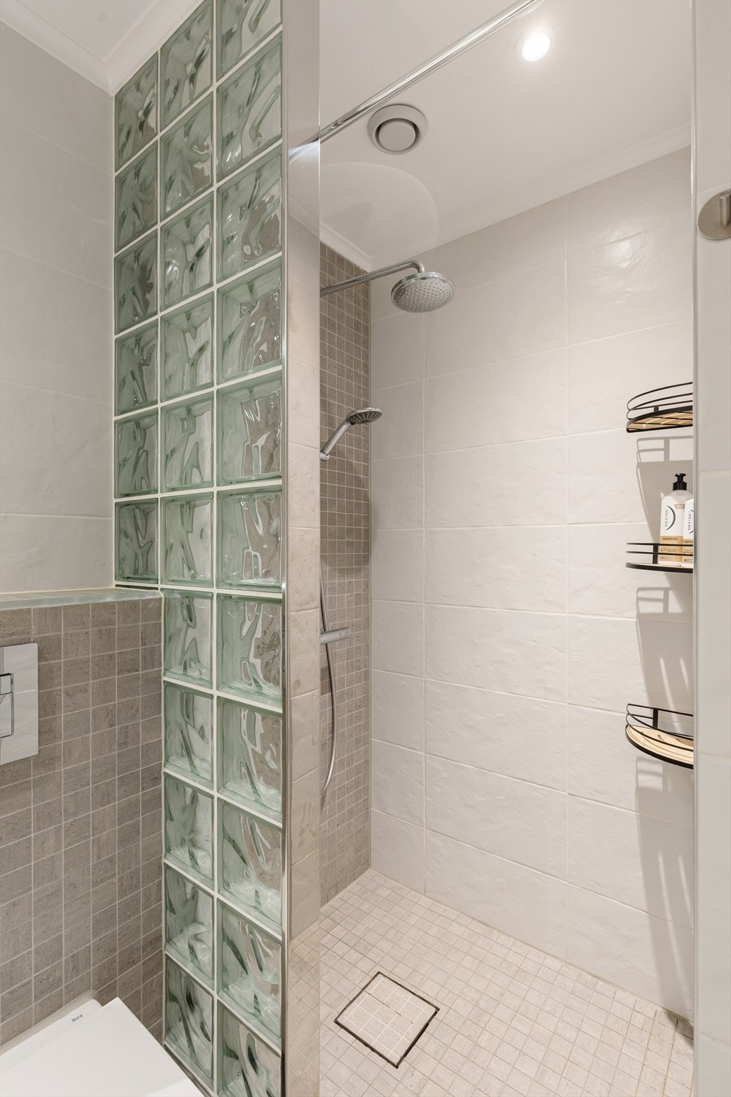 Badet har en romslig dusjnisje, vegghengt toalett og elektrisk håndkletørker. Galleribilde