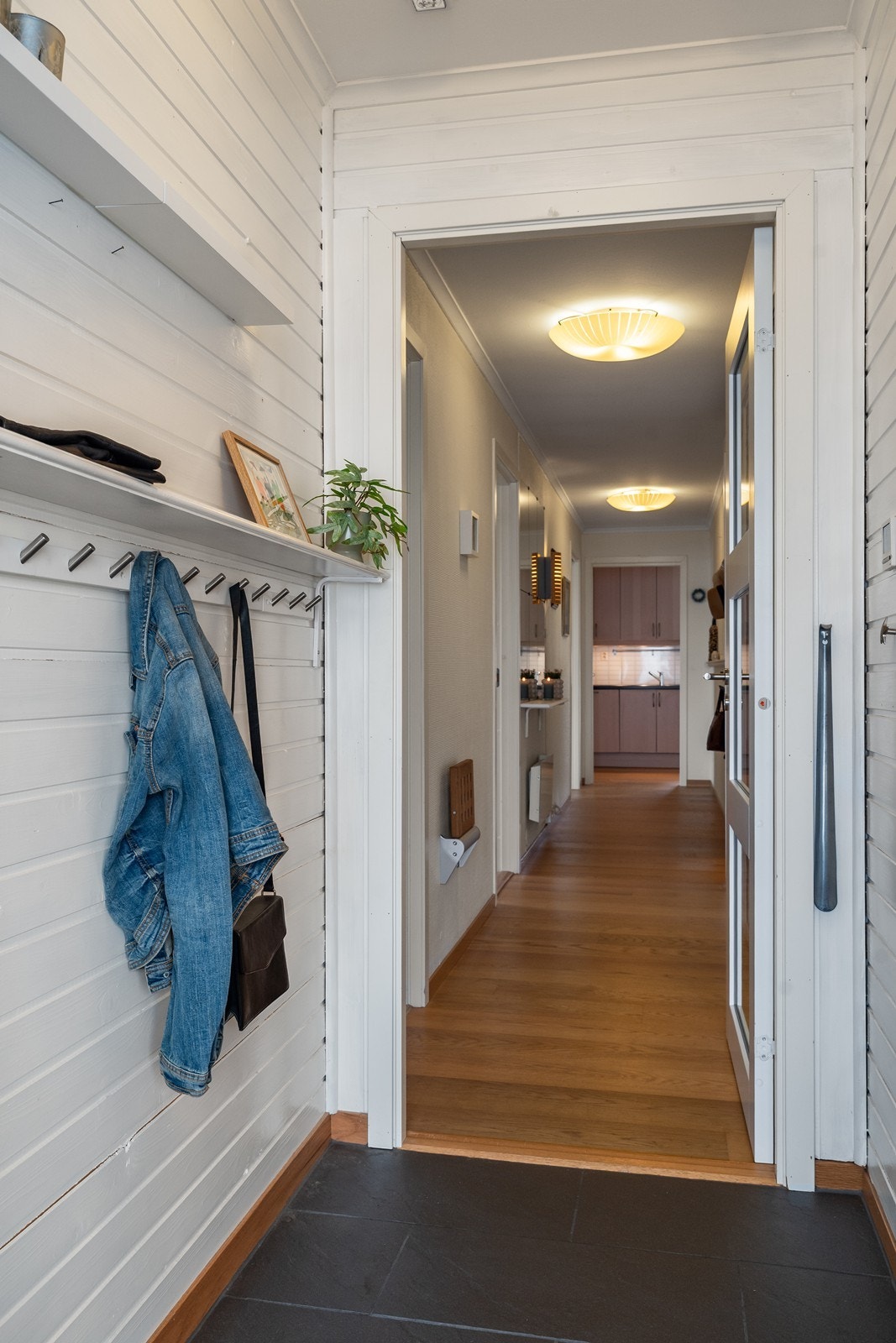 Lyst og innbydende vindfang med praktiske fliser på gulv og god plass til oppheng av yttertøy og oppbevaring. Galleribilde