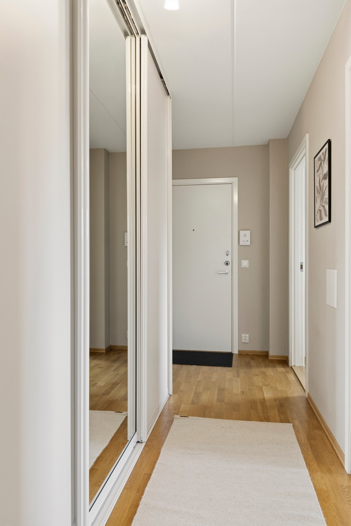 Romslig gang med stor skyvedørsgarderobe med speilfronter, som gir rikelig med oppbevaringsplass til klær, sko og annet utstyr. Galleribilde