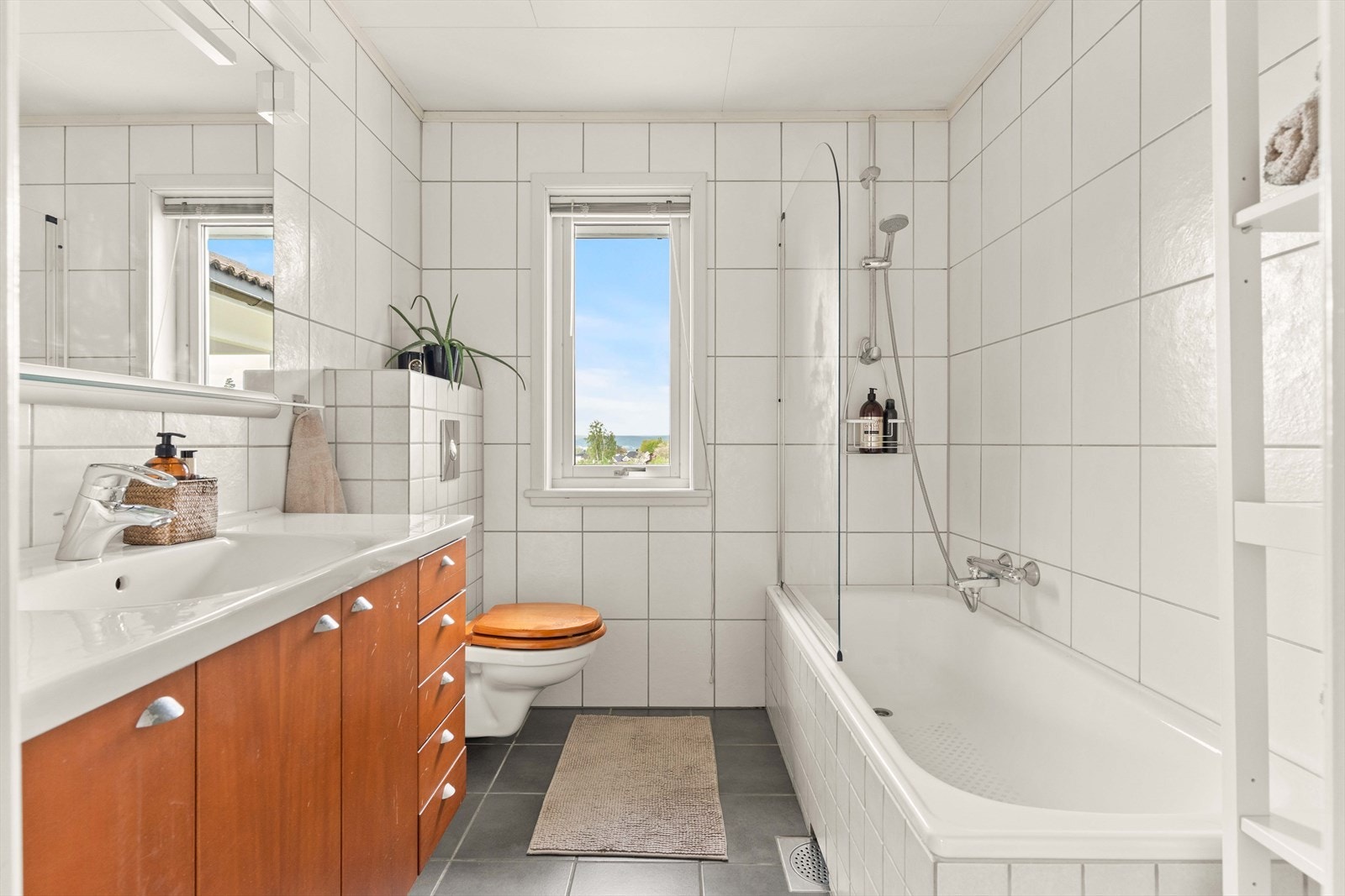 Badet i 1. etasje ble oppgradert i 2004 og har flislagte overflater, innebygget badekar med dusjvegg og vegghengt toalett. Galleribilde