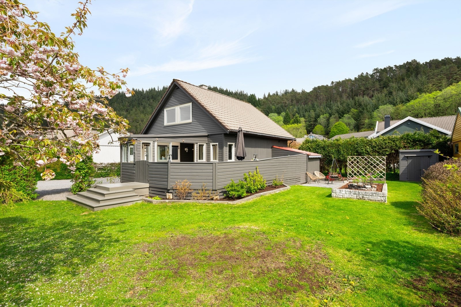 Boligens uteområde er svært flott opparbeidet med terrasse, platting og en frodig hage. Galleribilde