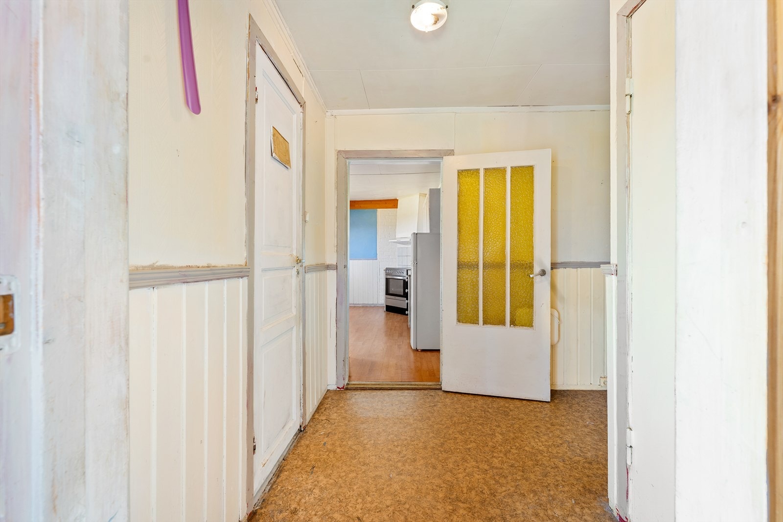 Boligen har vindfang, før en åpen gang med trapp til kjeller og loftsetasje til høyre, dør til badet til venstre og kjøkken og stue rett frem Galleribilde