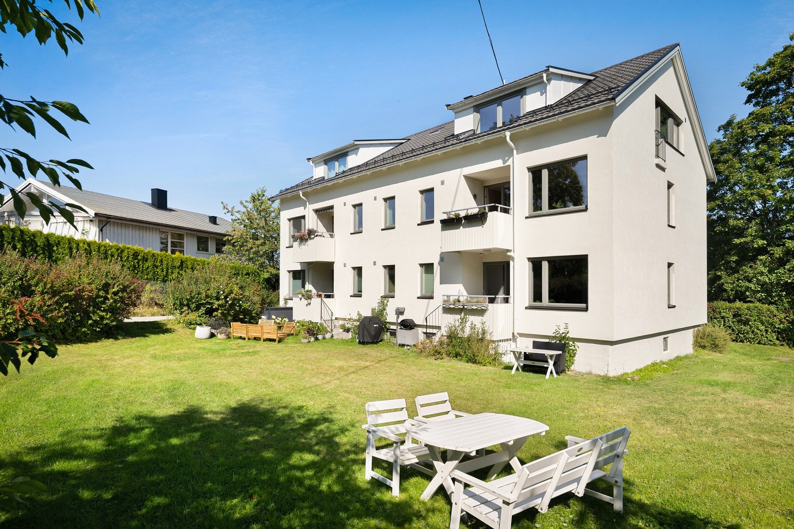 Eiendommen ligger fint til i grønne omgivelser, med plen, beplantning og høy hekk som skjermer uteområdet mot omgivelsene. Galleribilde