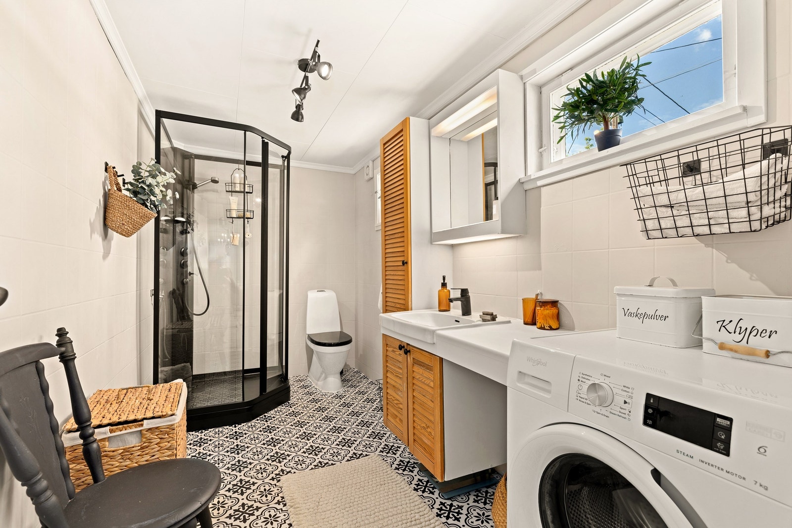 Badet er utstyrt med dusjkabinett, servant med underskap og opplegg for vaskemaskin. Galleribilde
