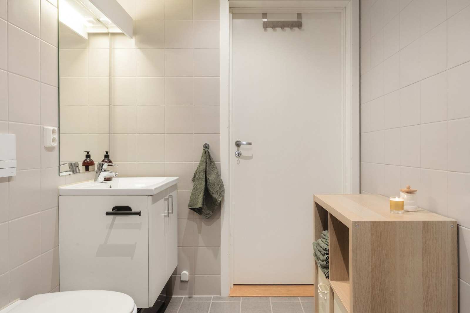 Badet er innredet med vegghengt toalett, servant med innredning, dusjhjørne og opplegg for vaskemaskin. Galleribilde