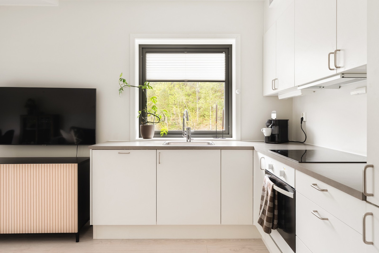 Flott kjøkken fra kvalitetsleverandøren HTH med hvite glatte fronter og laminat benkeplate. Galleribilde