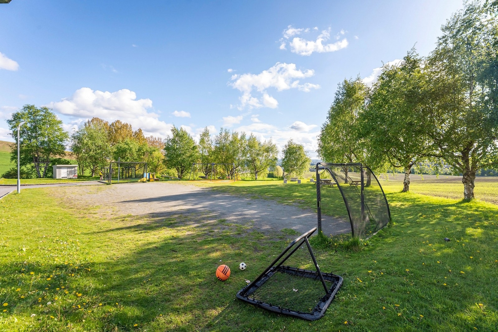 Felles parkområde med fotballøkke, sittegrupper og lekestativer. Galleribilde
