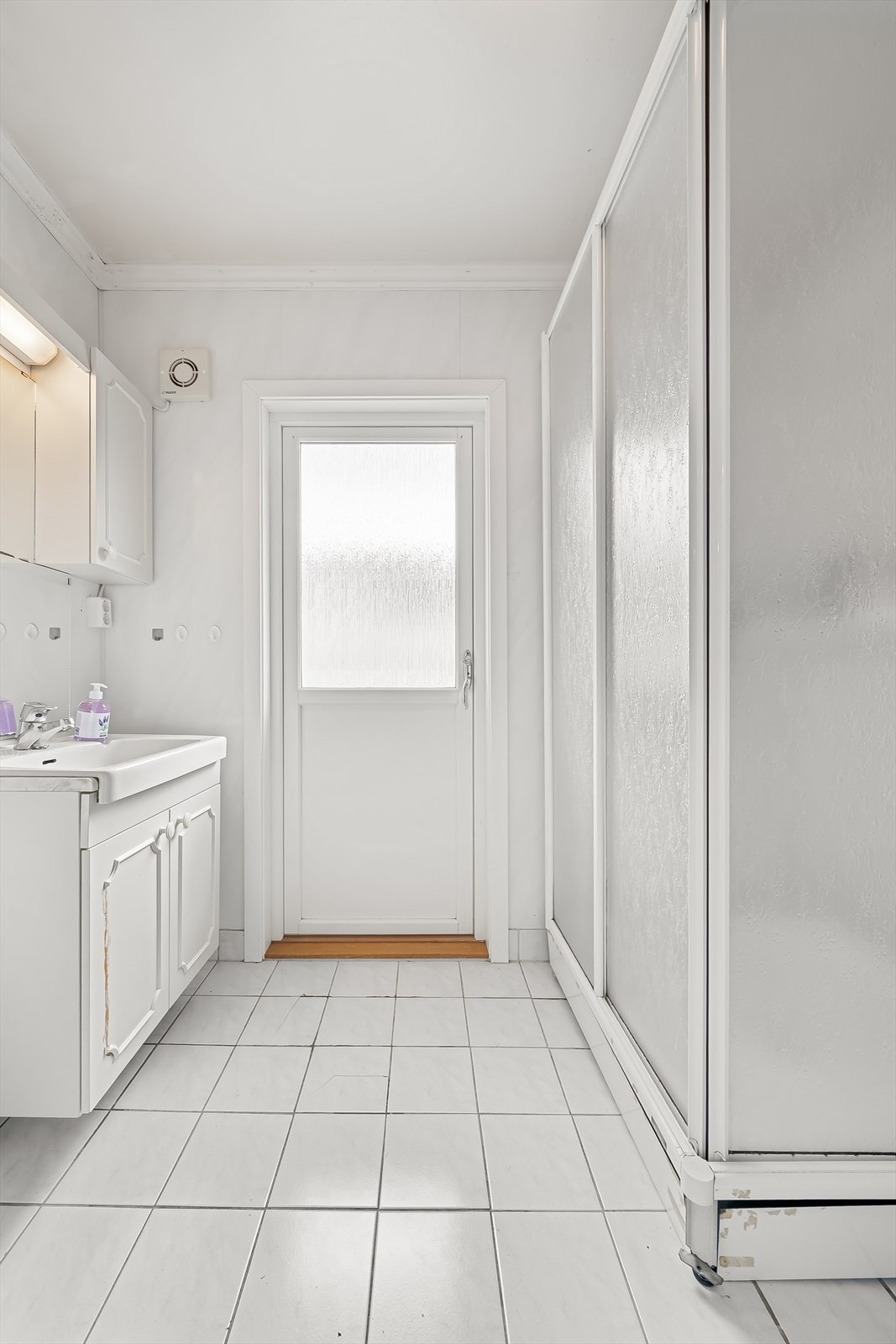 Badet har flislagt gulv og lys innredning. Galleribilde
