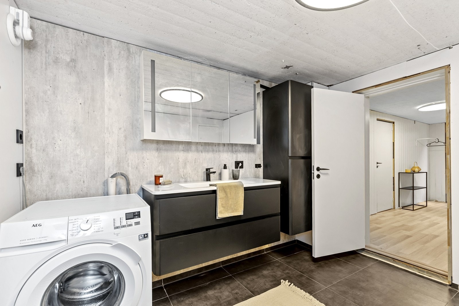 Badet er innredet med wc, dusjhjørne i glass, høyskap og vask i seksjon med underskuffer. I tillegg er det opplegg for vaskemaskin. Galleribilde