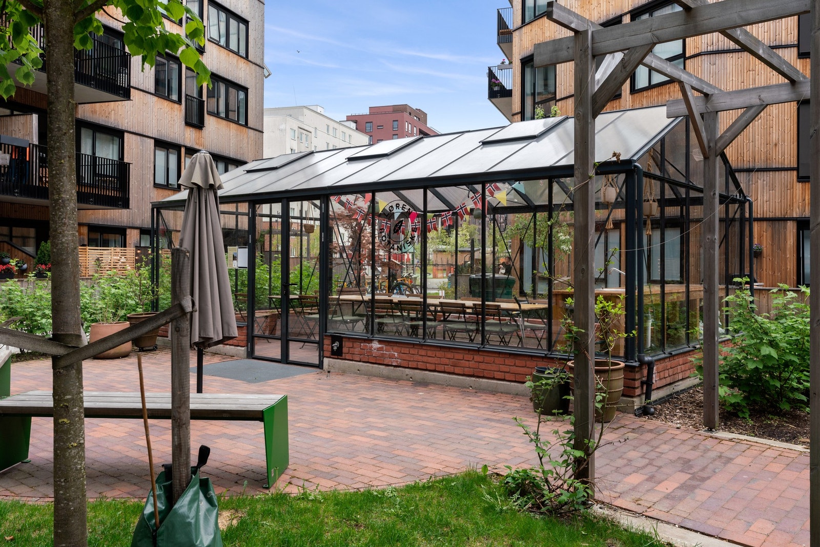 "Drivhus" i bakhagen med sitteplasser og langbord. Galleribilde
