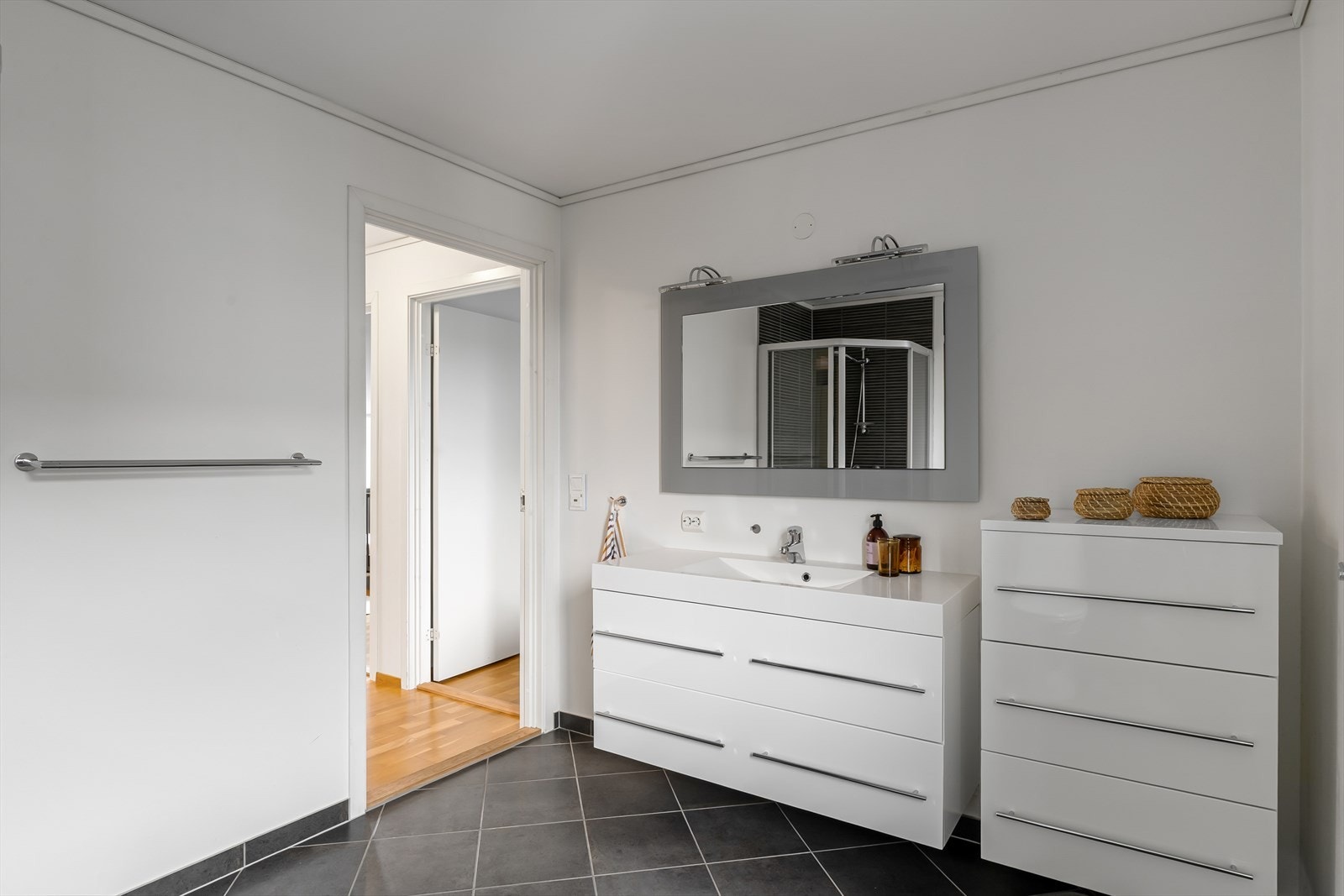 Badet er innredet med dusjhjørne, toalett og en bred servantinnredning med god oppbevaringsplass. Galleribilde