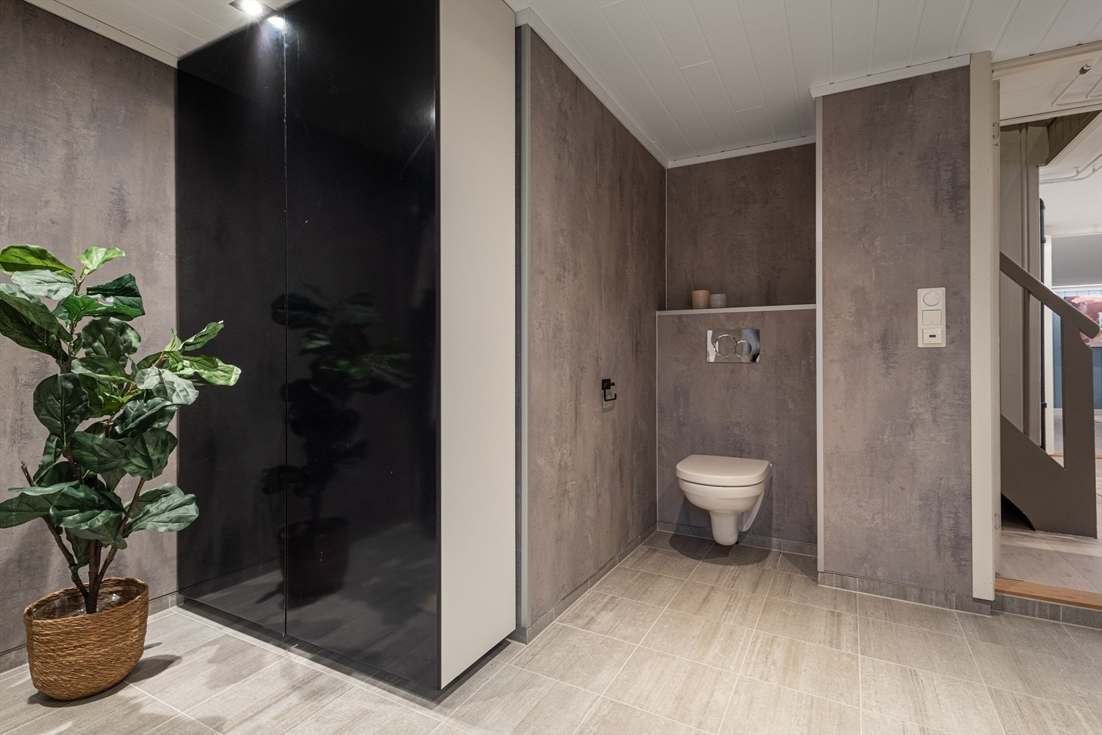 Også dette badet har vegghengt toalett og elektriske varmekabler i det flislagte gulvet. Galleribilde