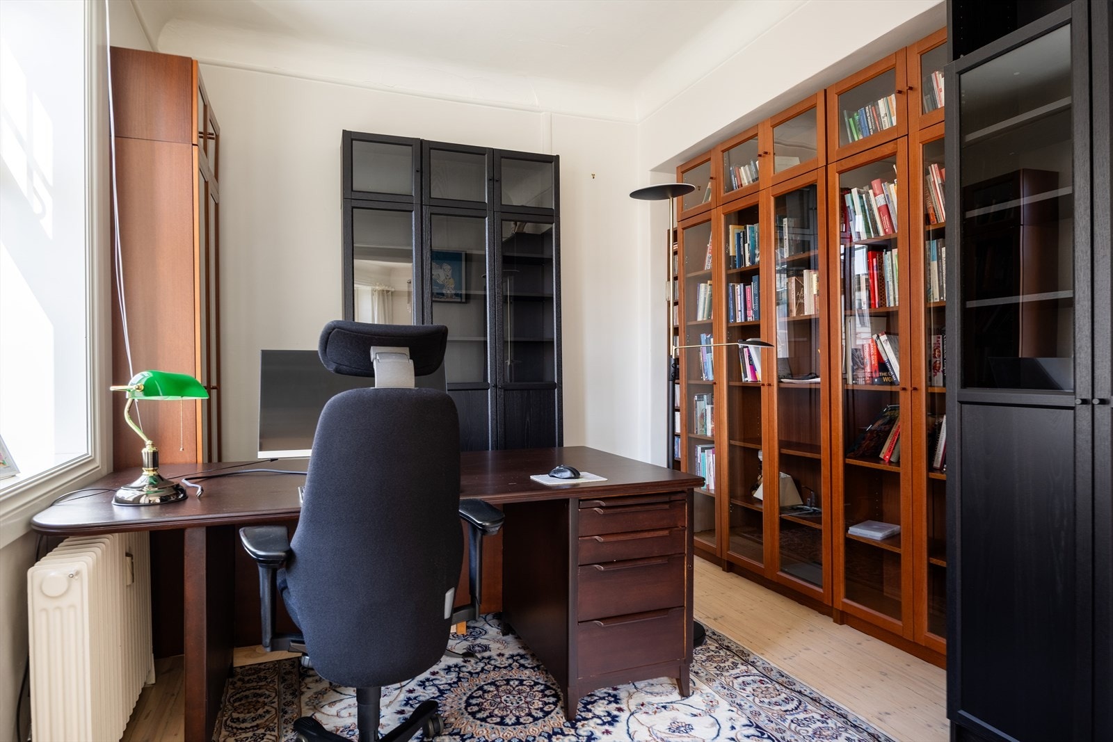Videre inn fra stuen kommer du til et stort rom som kan brukes som hjemmekontor/bibliotek. Rommet er godkjent som soverom Galleribilde