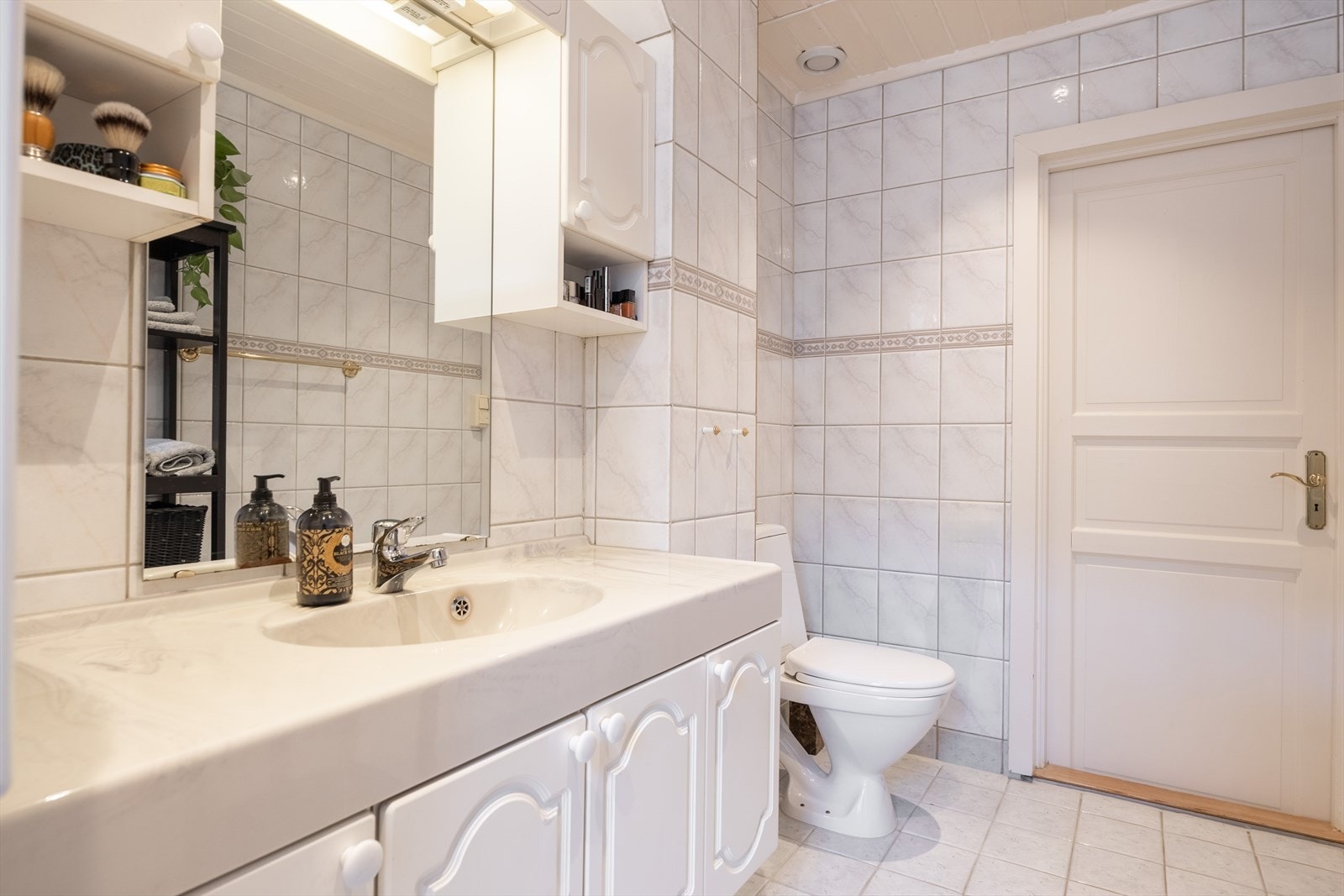 Innredning bestående av servant med speil, WC og badekar/dusj Galleribilde