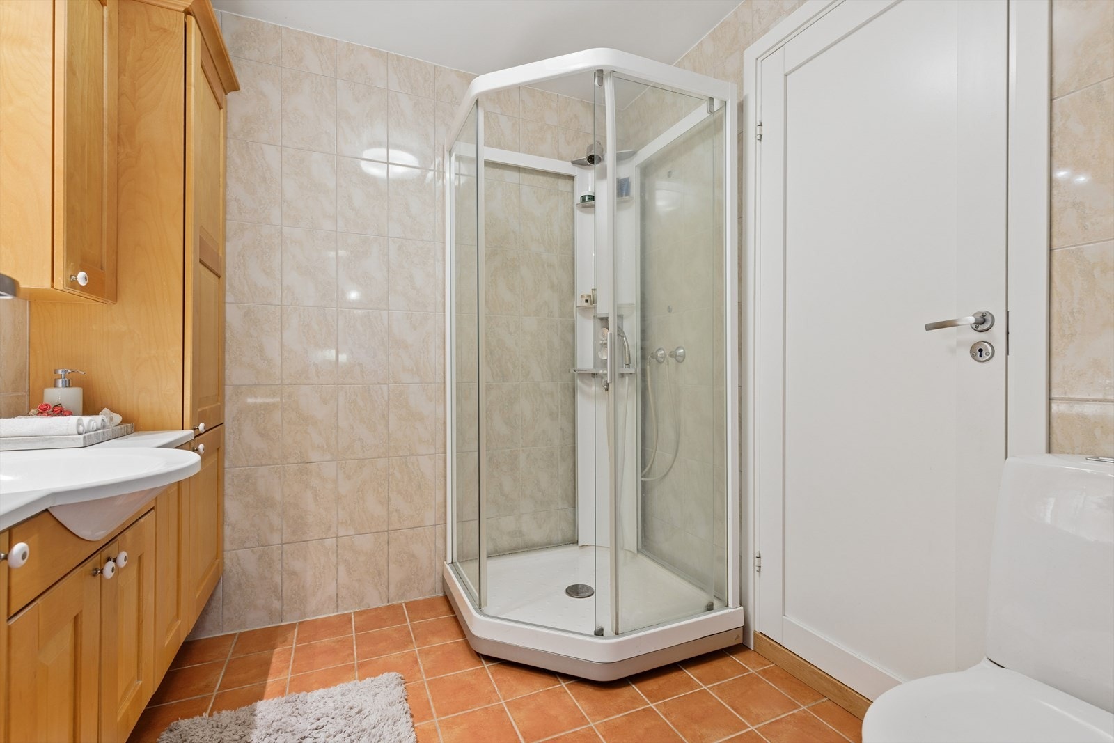 Badet i første etasje har fliser på gulv og vegger, varmekabler og dusjkabinett. Galleribilde