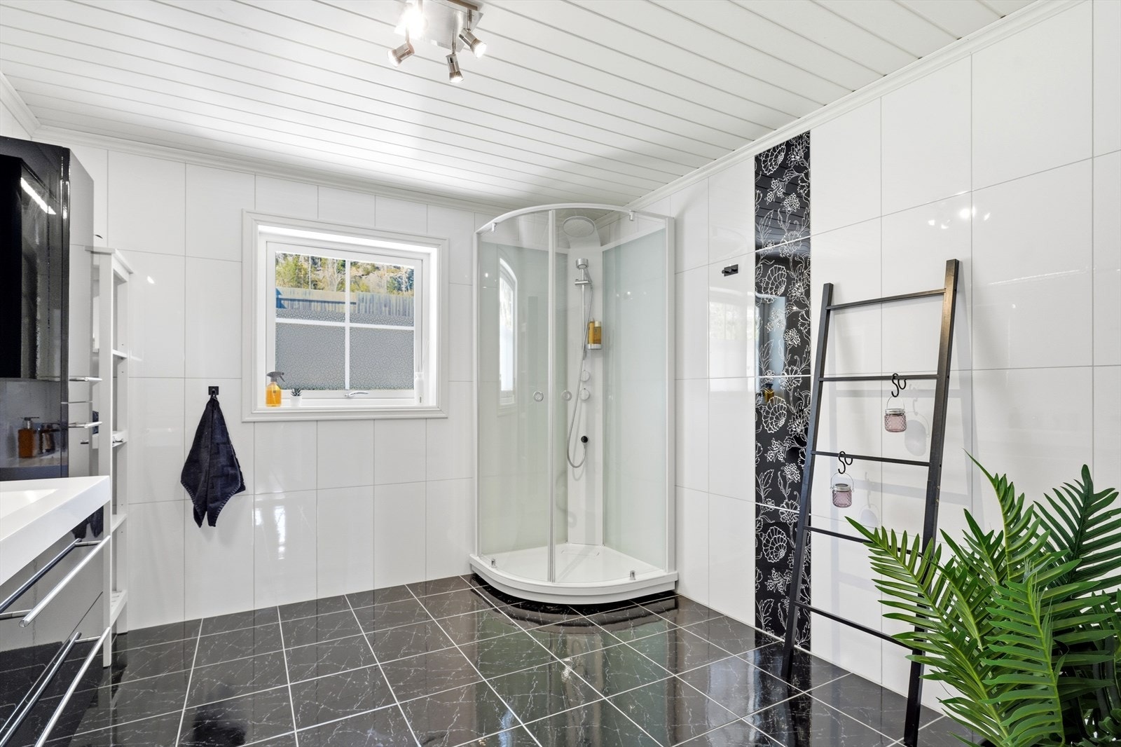 Badet er utstyrt med dusjkabinett, veggmontert toalett og servantinnredning. Galleribilde