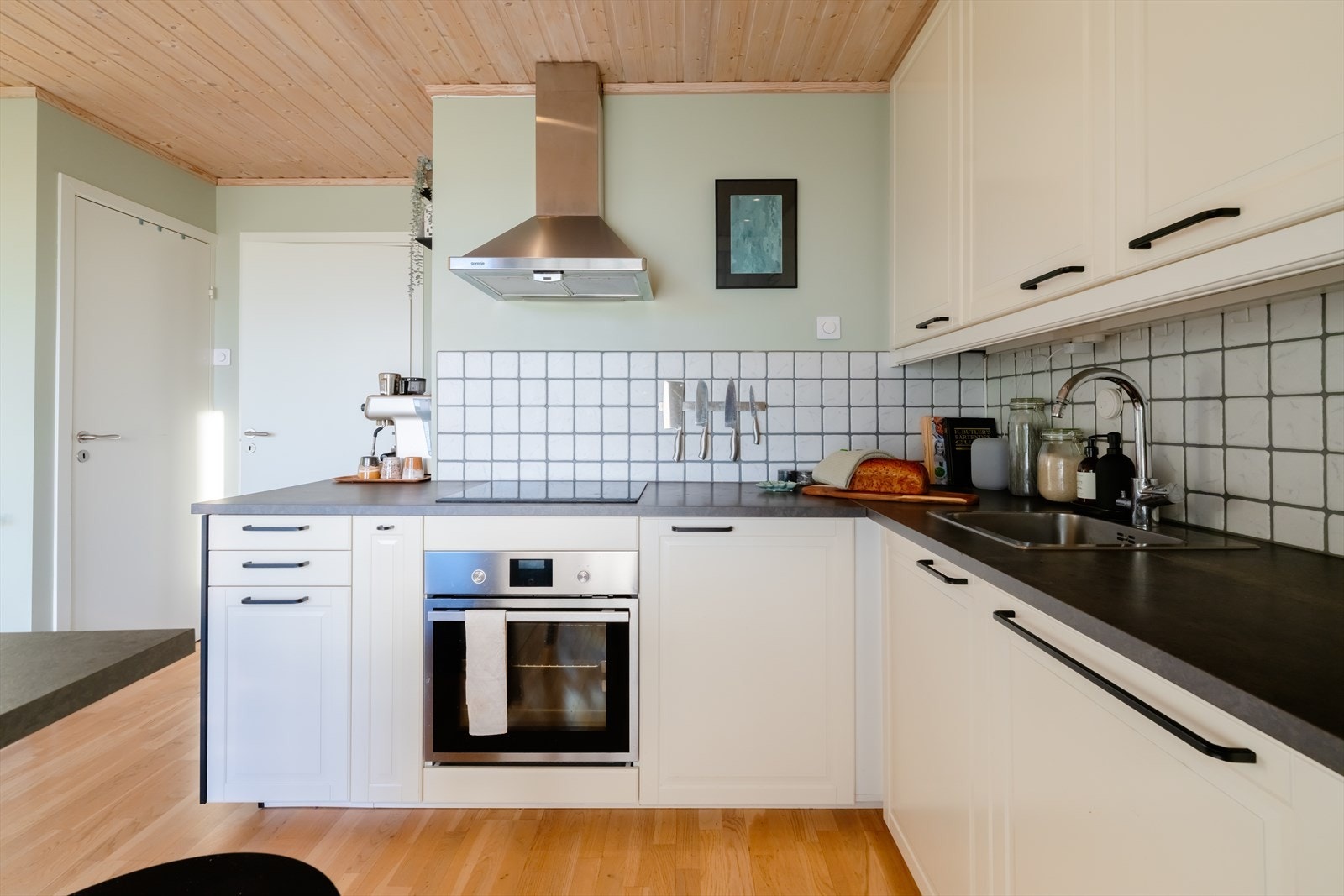 Lys og tidløs kjøkkeninnredning fra 2016, iht. tidligere salgsoppgave, med profilerte, fabrikklakkerte fronter og benkeplate i laminat med nedfelt kum i rustfritt stål. Galleribilde