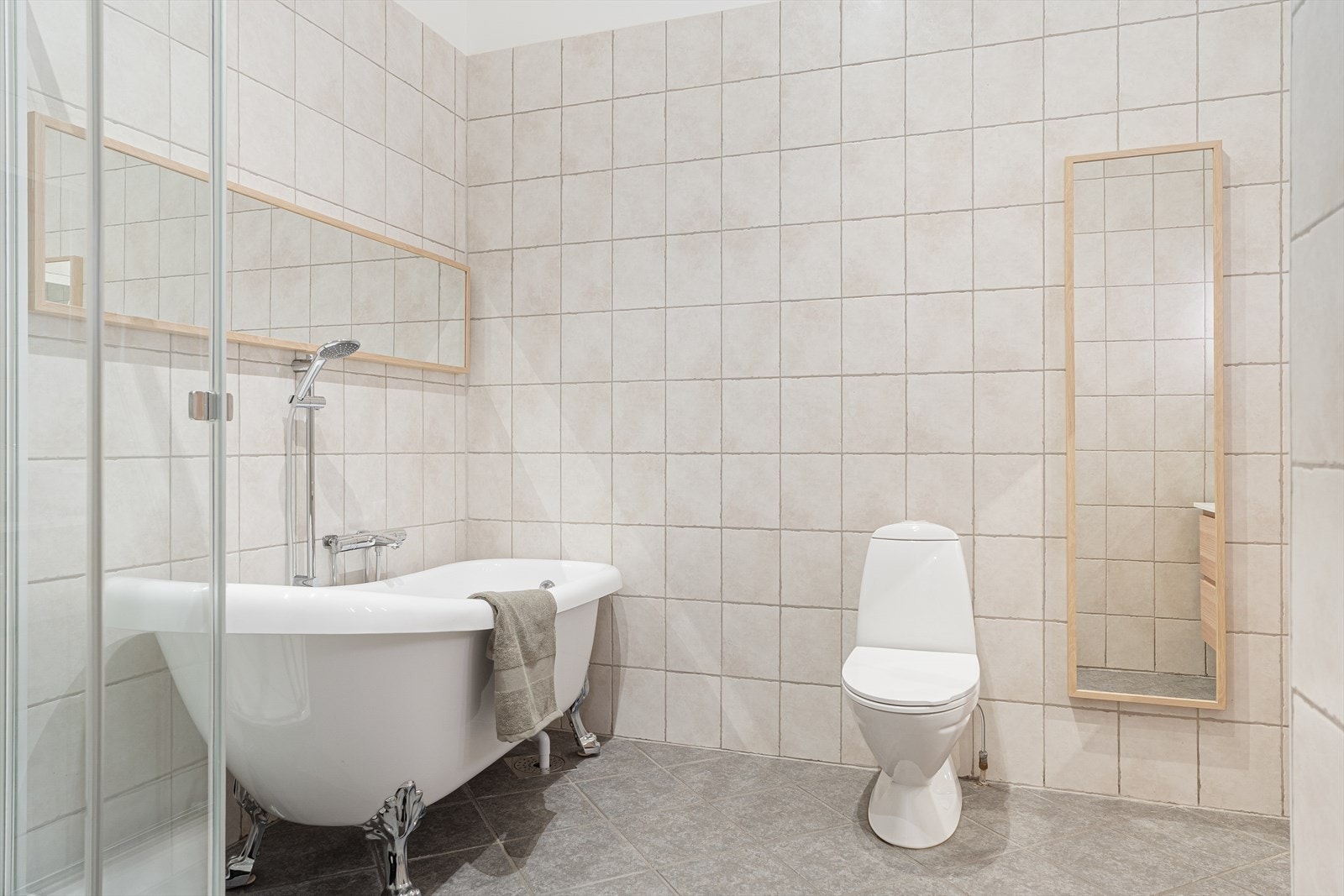 Badet på loftet er tidløst og pent med fliser på vegger og gulv, samt elektriske varmekabler i gulvet Galleribilde