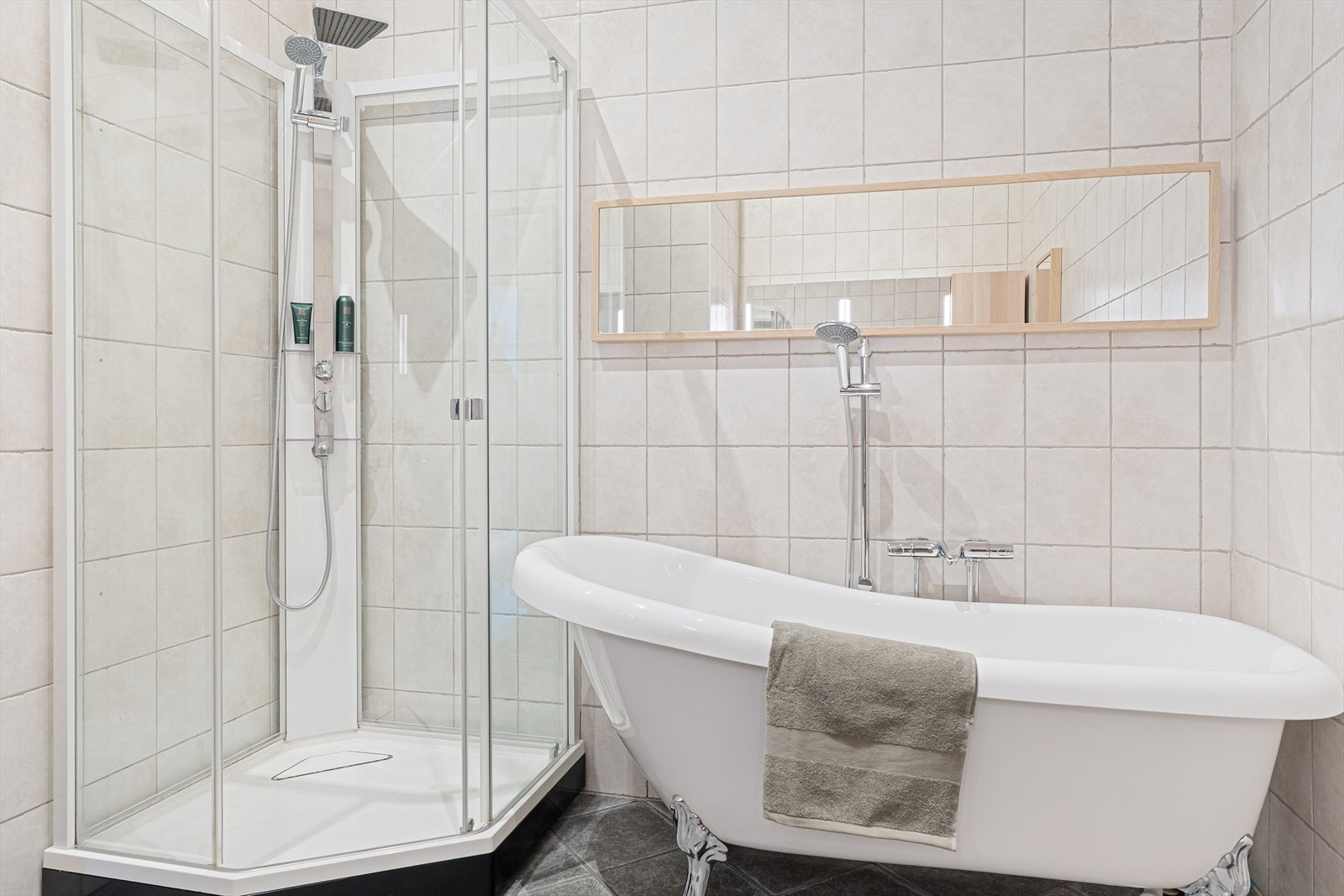 Badet er innredet med moderne baderomsinnredning fra 2016, gulvstående toalett, badekar og dusjkabinett Galleribilde