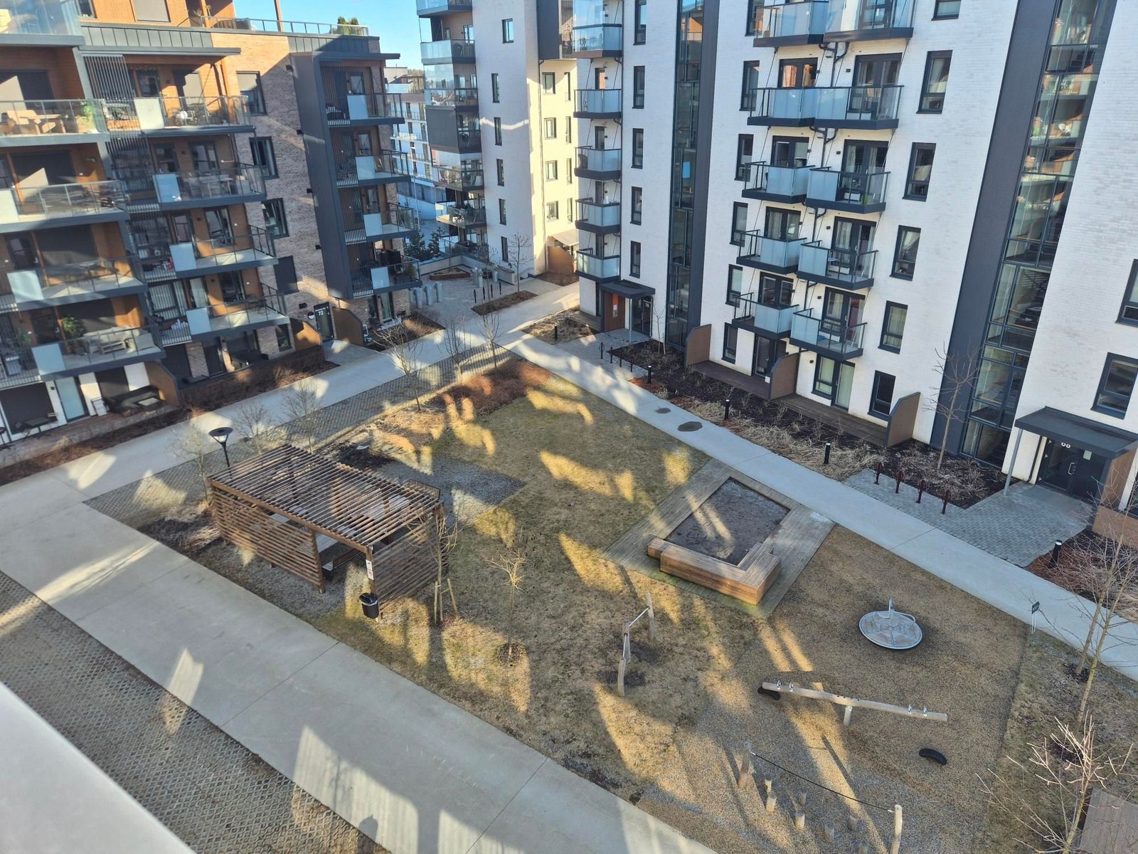 Stilrene og gjennomarbeidede fellesområder mellom byggene gir et moderne og eksklusivt preg på hele boligmiljøet. Galleribilde