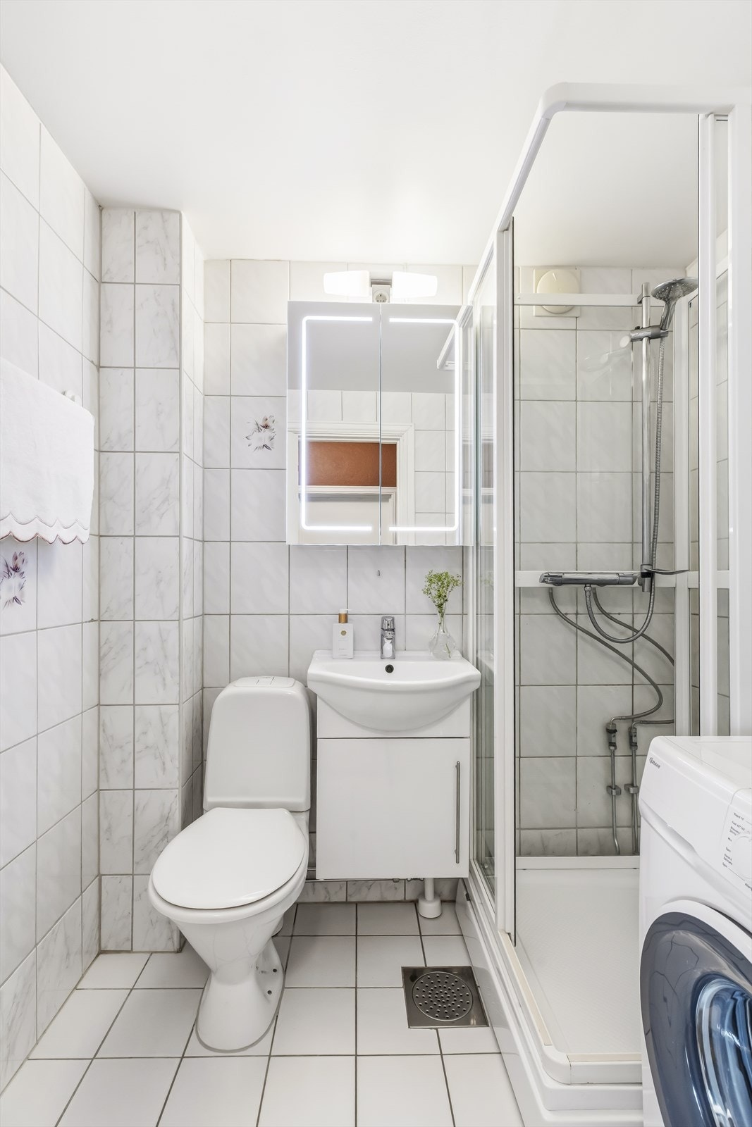Badet er rehabilitert i regi av borettslaget og fremstår tidløst og funksjonelt med fliser på gulv og vegger, malt tak og behagelige varmekabler i gulv. Galleribilde