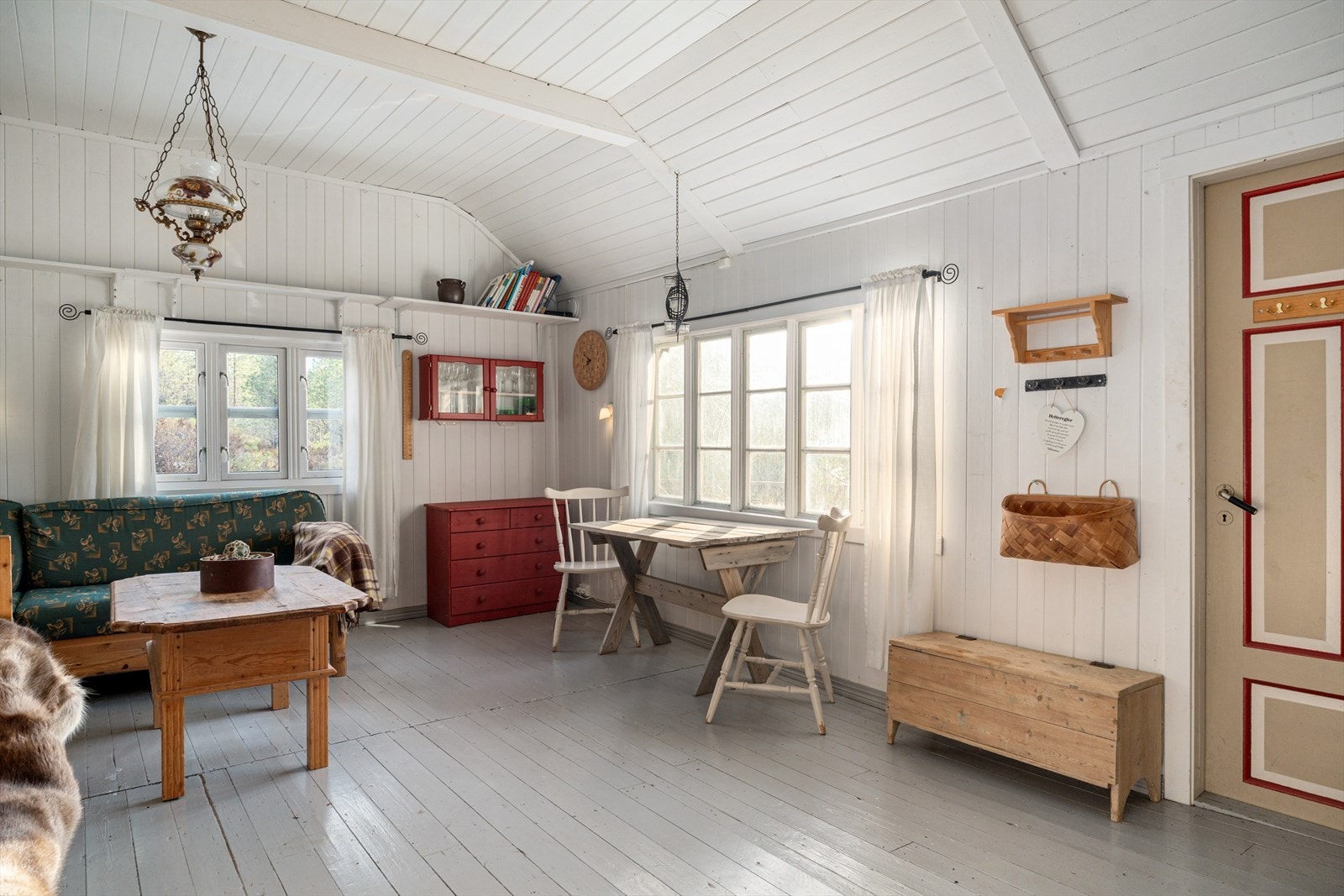 Hytte har stue/kjøkken i åpen løsning, vindfang, ett soverom og hems. Galleribilde