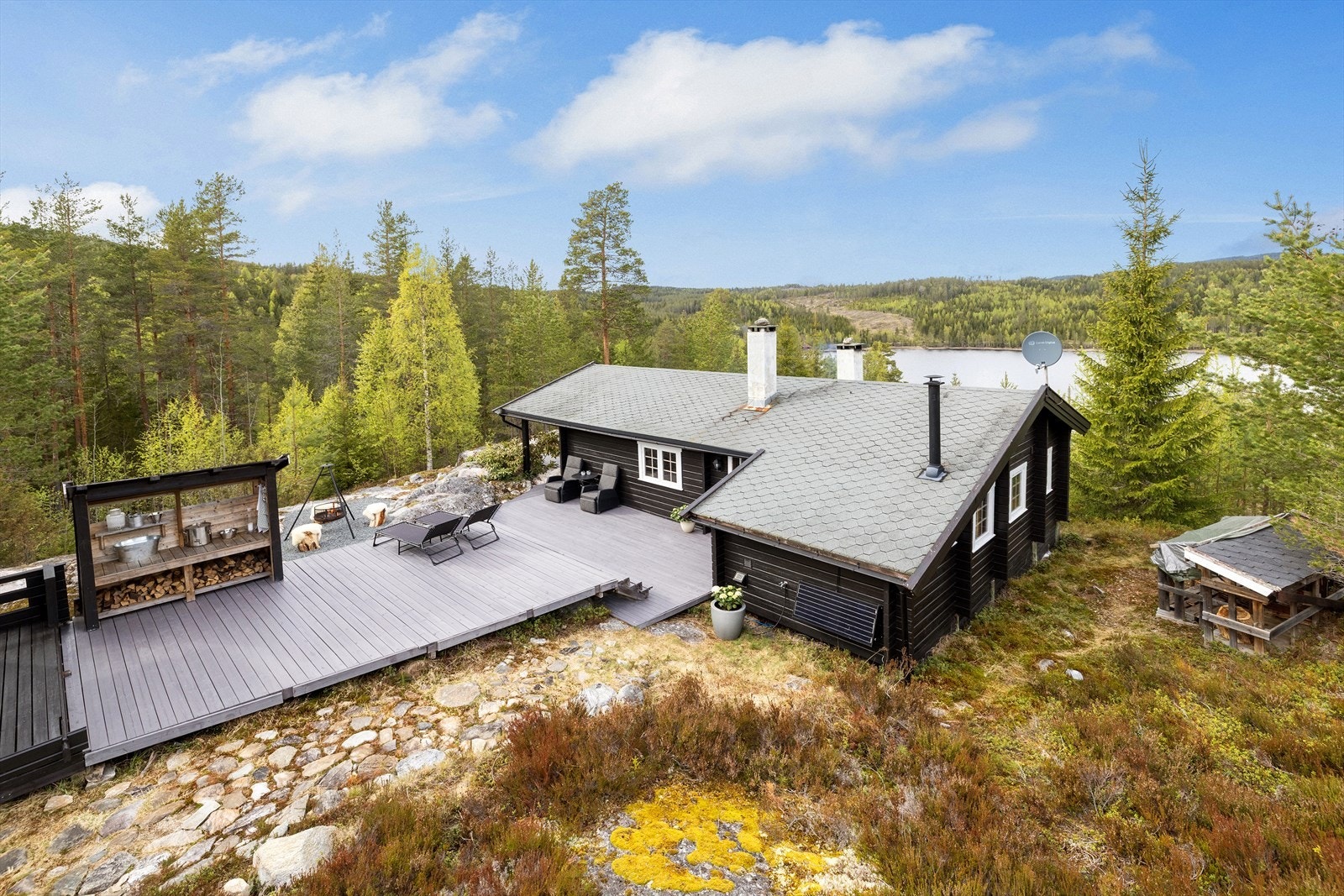 Eiendommen består av en laftet hytte og et frittstående anneks, omkranset av store uteplasser og naturtomt. Galleribilde