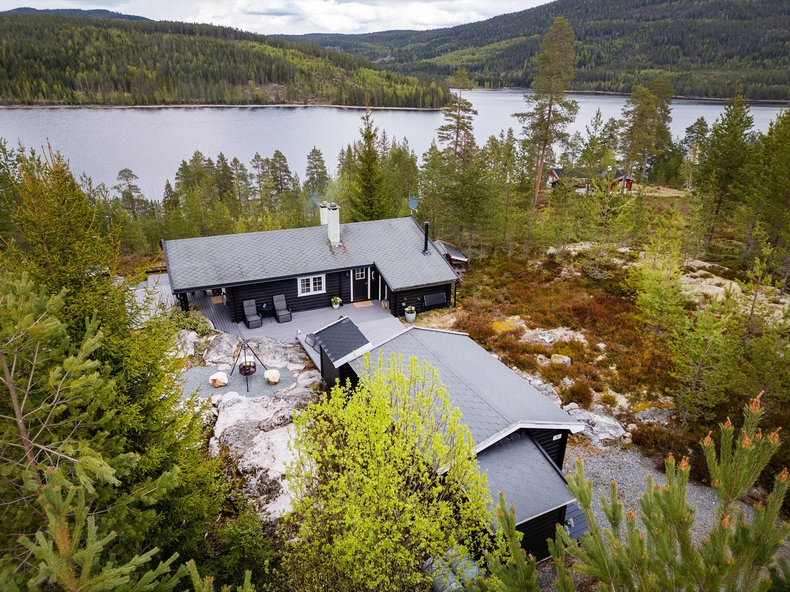 Oversiktsbilde som viser hyttas plassering i terrenget, med anneks og parkering på egen tomt. Galleribilde