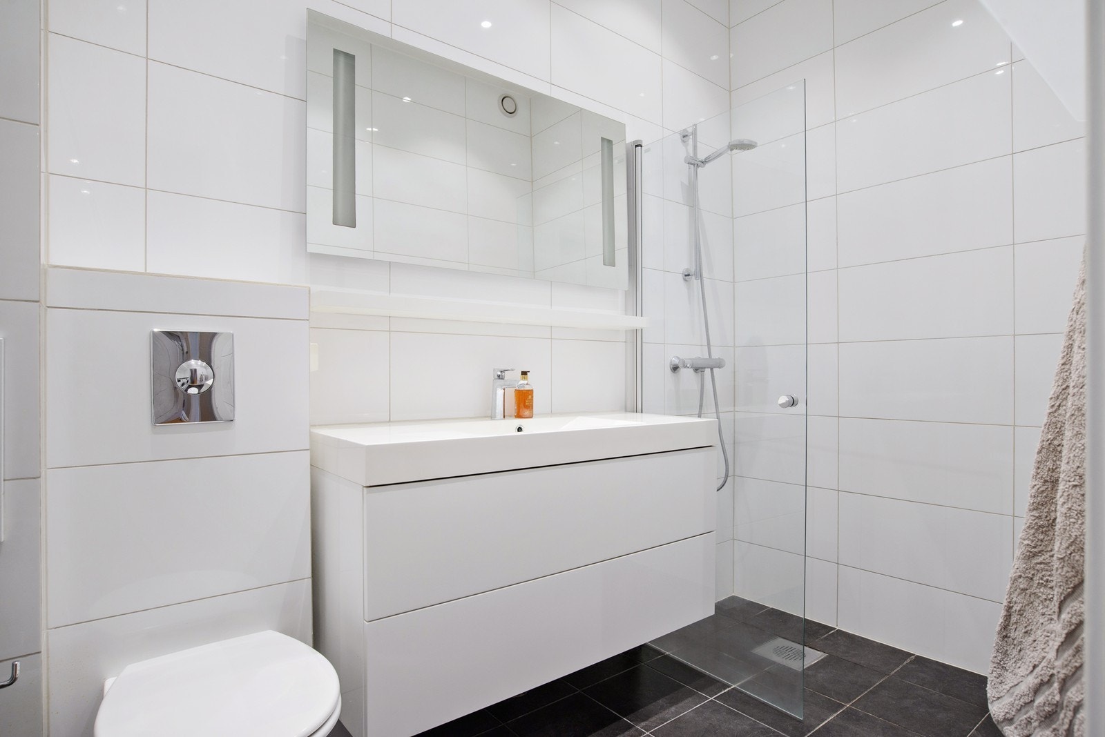 Badet har en stor dusjnisje og delikate fliser Galleribilde