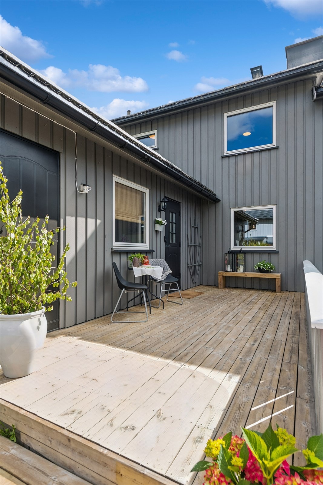 Ved inngangspartiet er det en hyggelig treterrasse med plass til en sittegruppe. Galleribilde
