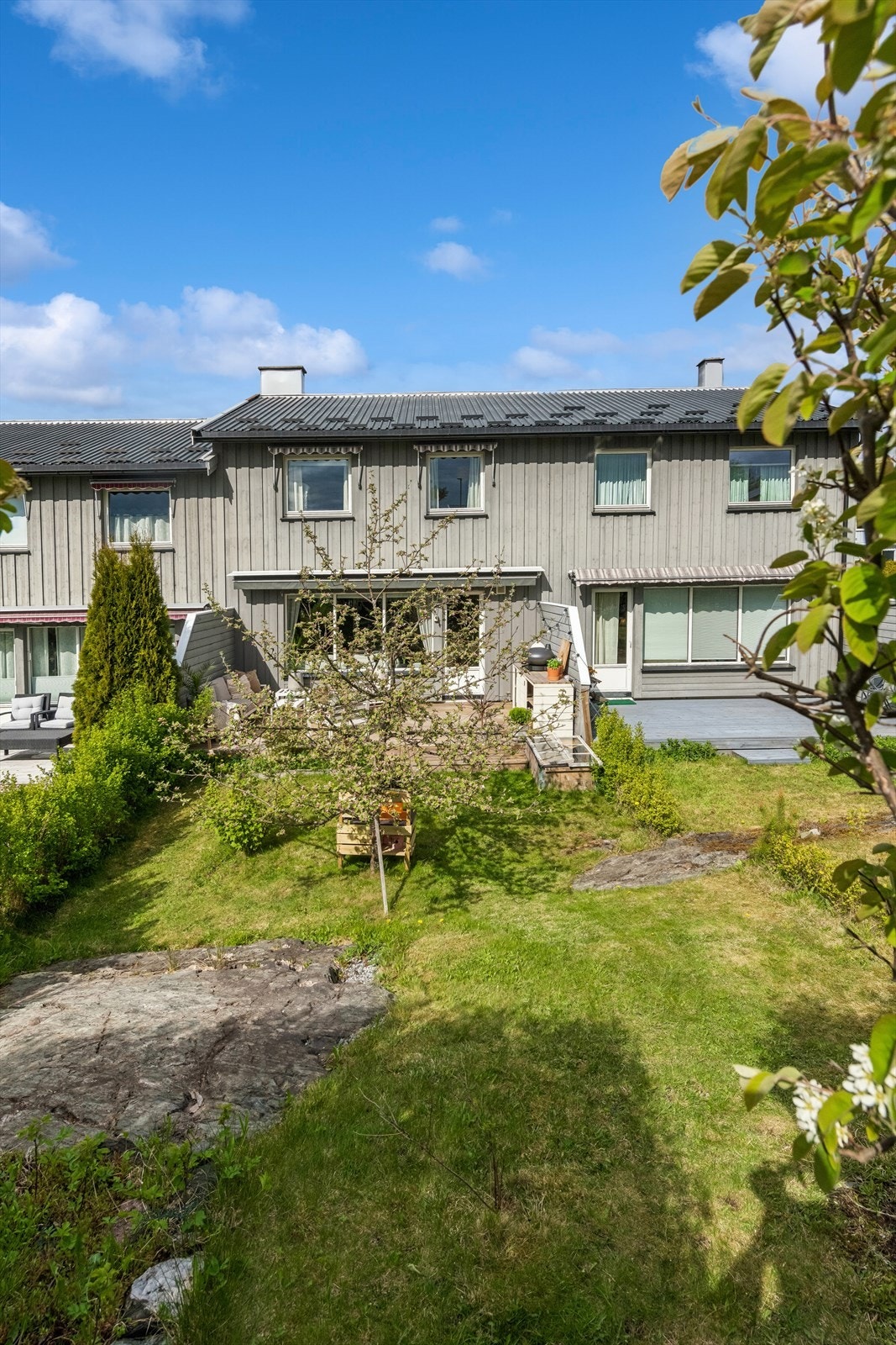 Eiendommen har en relativt flat tomt som er opparbeidet med plen og beplantning. Galleribilde