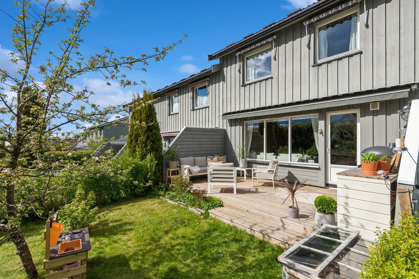 Gjennomgående rekkehus med uteplass og hage på begge sider av boligen. Galleribilde