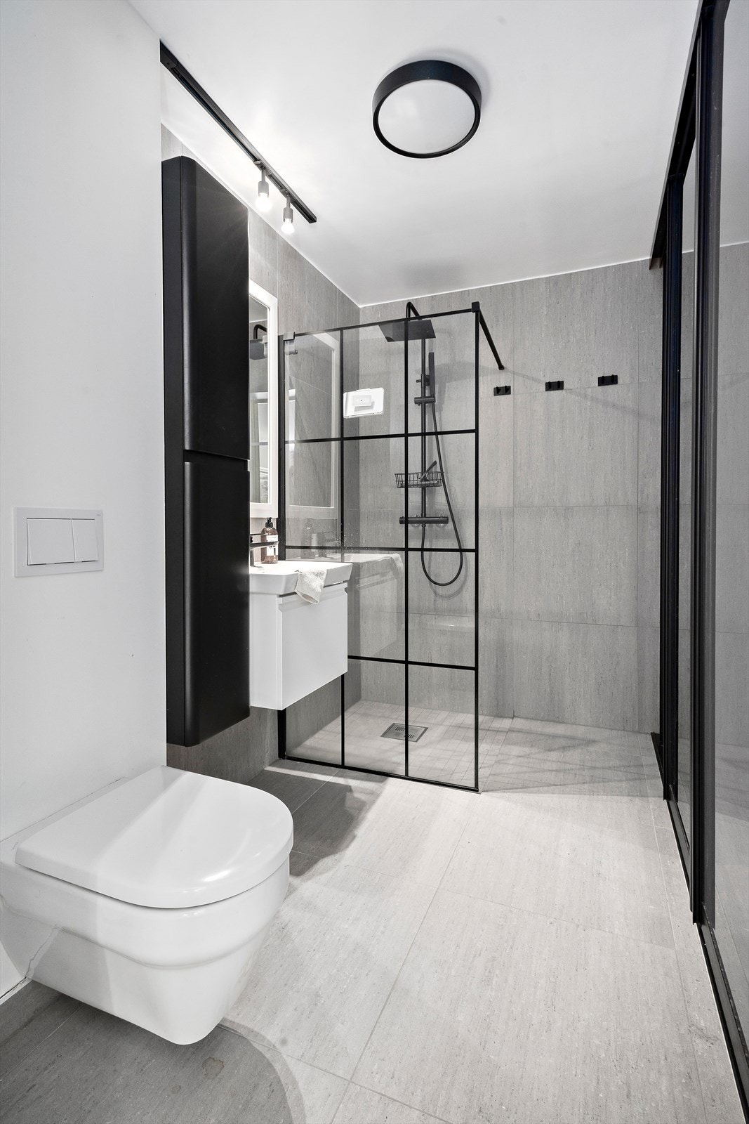 Det tilhørende badet har en stilren utførelse med mørke detaljer og dusjsone. Galleribilde