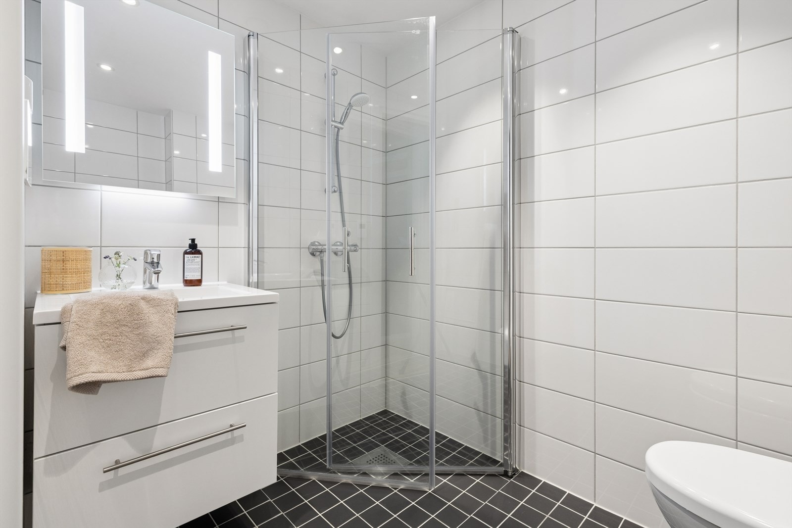 Pent flislagt baderom med vannbåren gulvvarme og nedsenket himling med innfelte downlights. Galleribilde