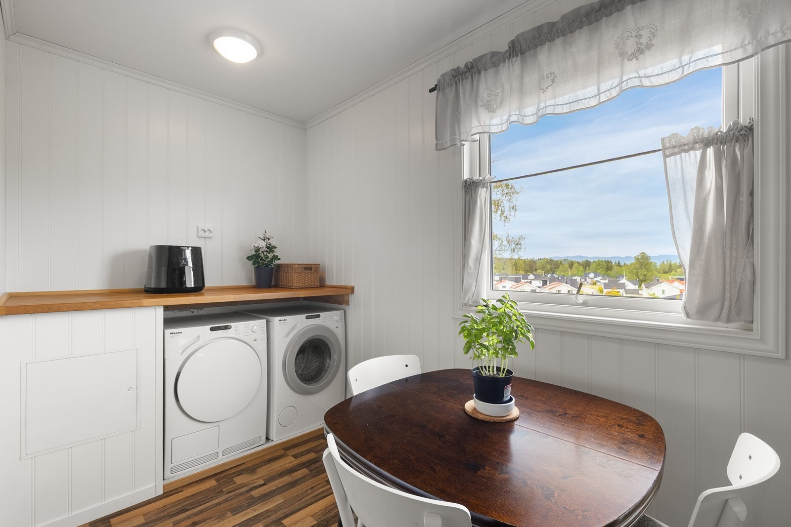Egen sone på kjøkkenet med opplegg for vaskemaskin, gulvbelegg med oppkant og sluk. Galleribilde