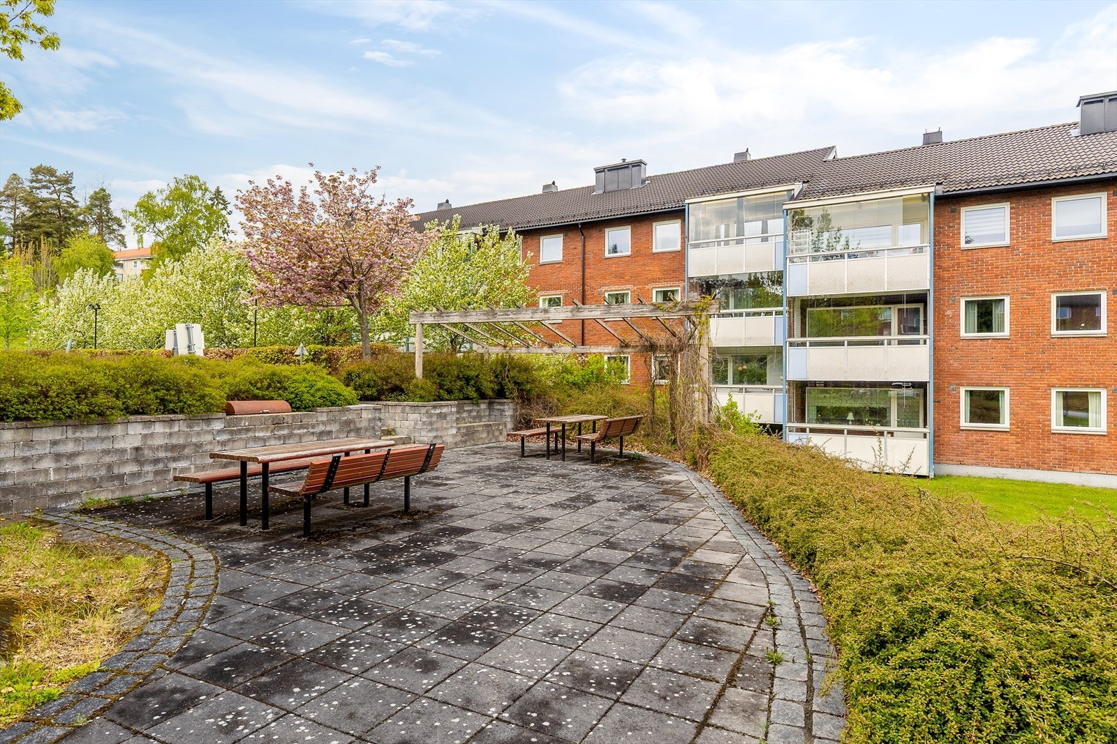 Hyggelig uteplass med pergola og benker i fellesarealet. Galleribilde