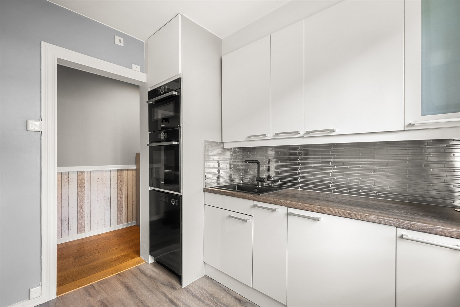 Stilrent kjøkken med glatte fronter og laminert benkeplate. Galleribilde
