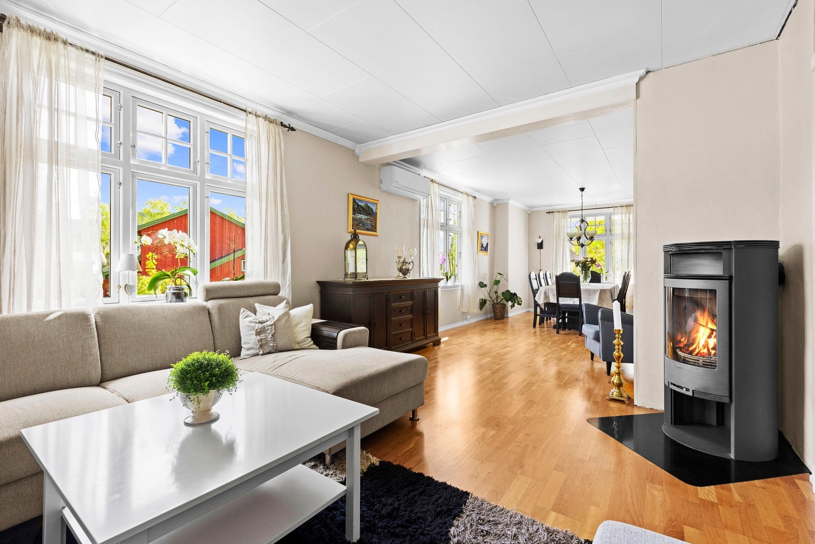 Romslig sofasonen med god sitteplass, store vindusflater som slipper inn rikelig med dagslys og fin sammenheng mot resten av stuen. Galleribilde