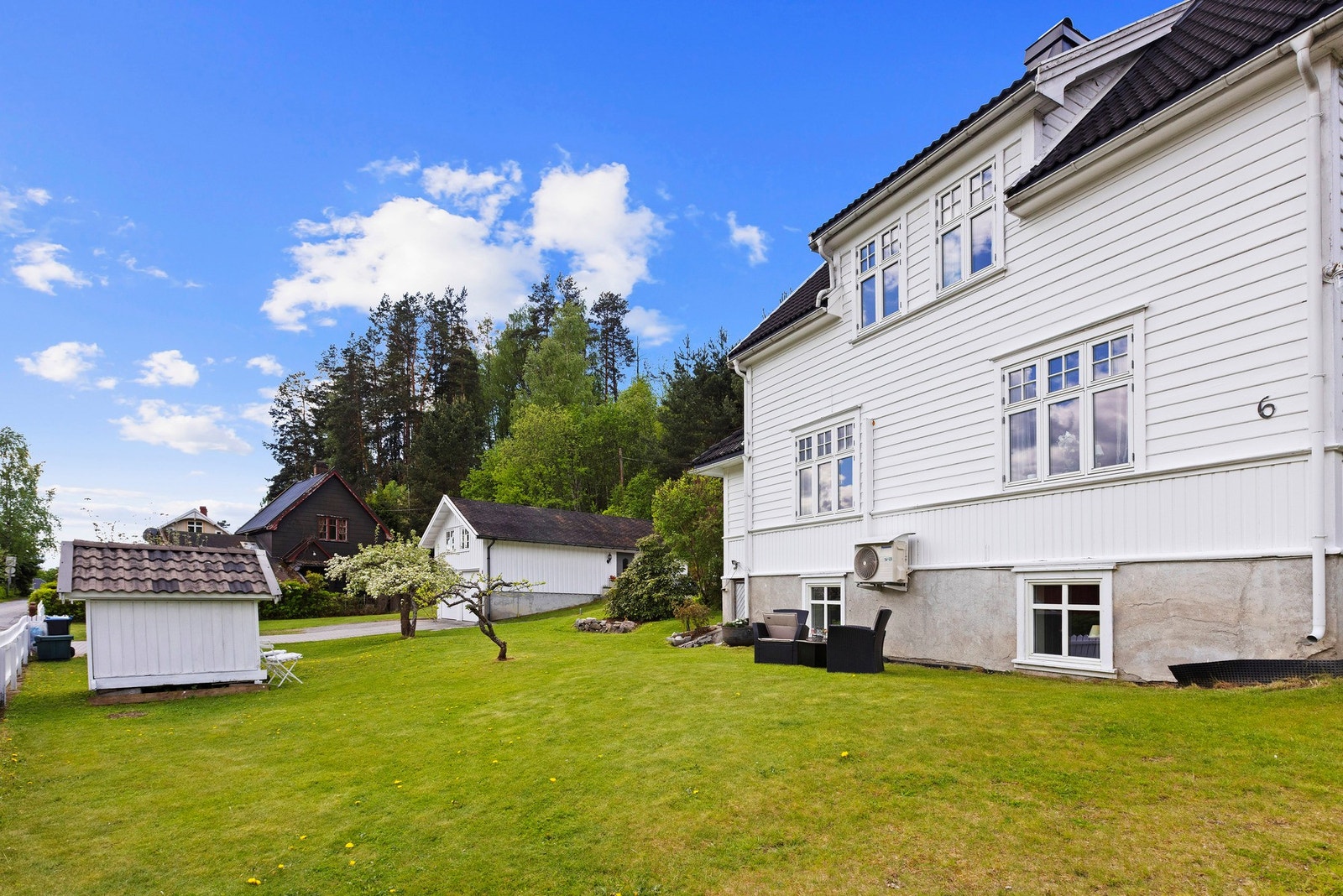 Flott hage med epletre og annen beplantning, samt en koselig lekestue. Galleribilde