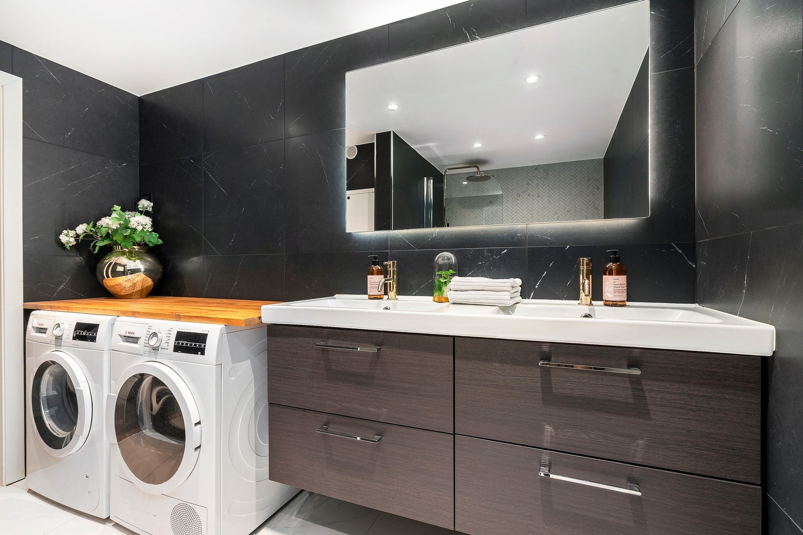Badet er innredet med vegghengt servantinnredning med dobbel servant, speil med sidelys, samt opplegg for vaskemaskin/tørketrommel. Galleribilde